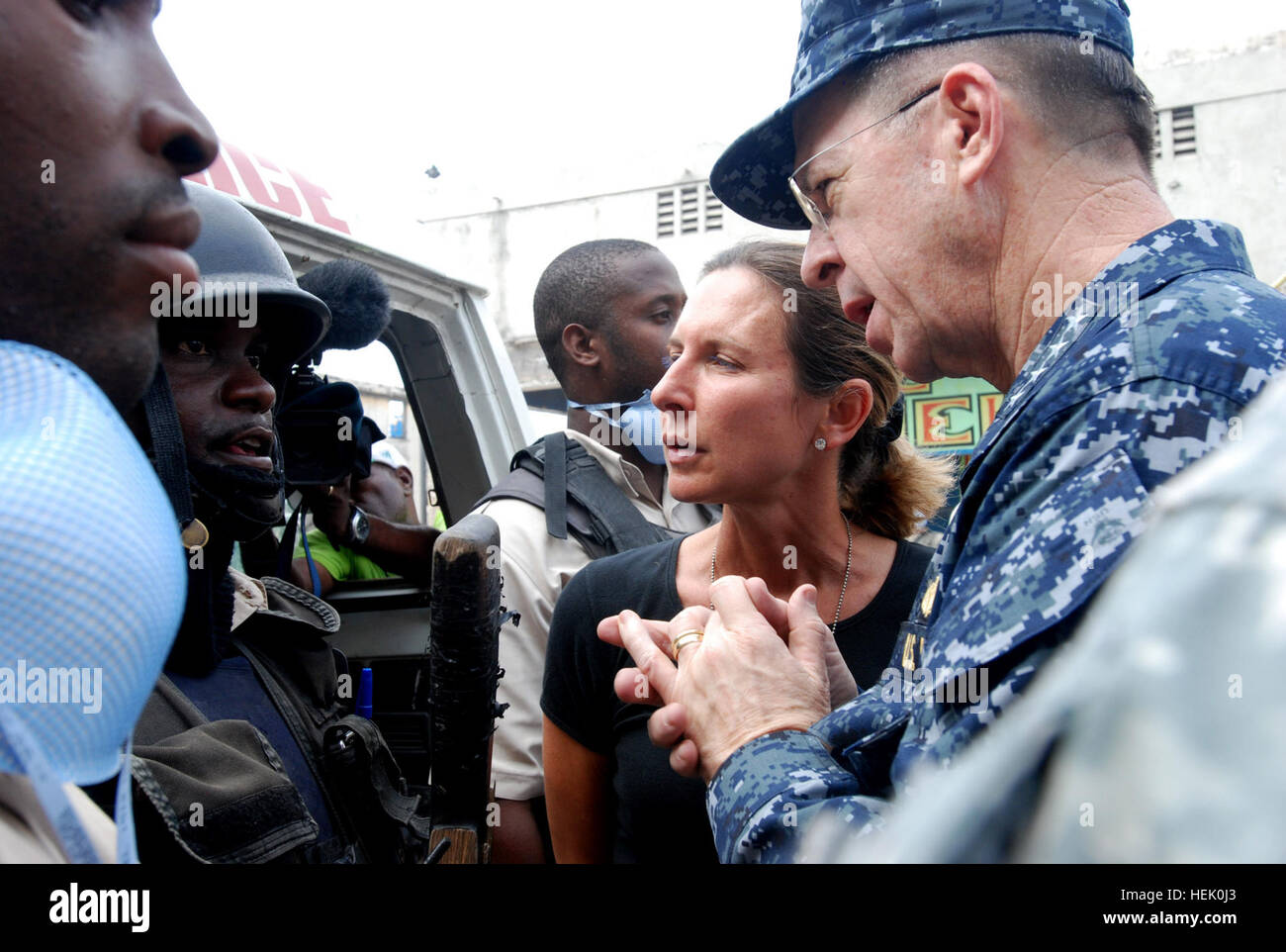 Navy Adm. Mike Mullen, chairman of the Joint Chiefs of Staff, speaks with Haitian National Police while visiting a rubble removal site in Port-au-Prince on Feb. 26. Italian Interagency Task Force soldiers, the Center of National Equipment and 2nd Brigade Combat Team Paratroopers have been working together to clear rubble from the streets of the city. (U.S. Army photo by Pfc. Kissta M. Feldner, 2BCT PAO) Chairman of the Joint Chiefs of Staff Visits With 2nd Brigade Combat Team Soldiers in Haiti 255266 Stock Photo