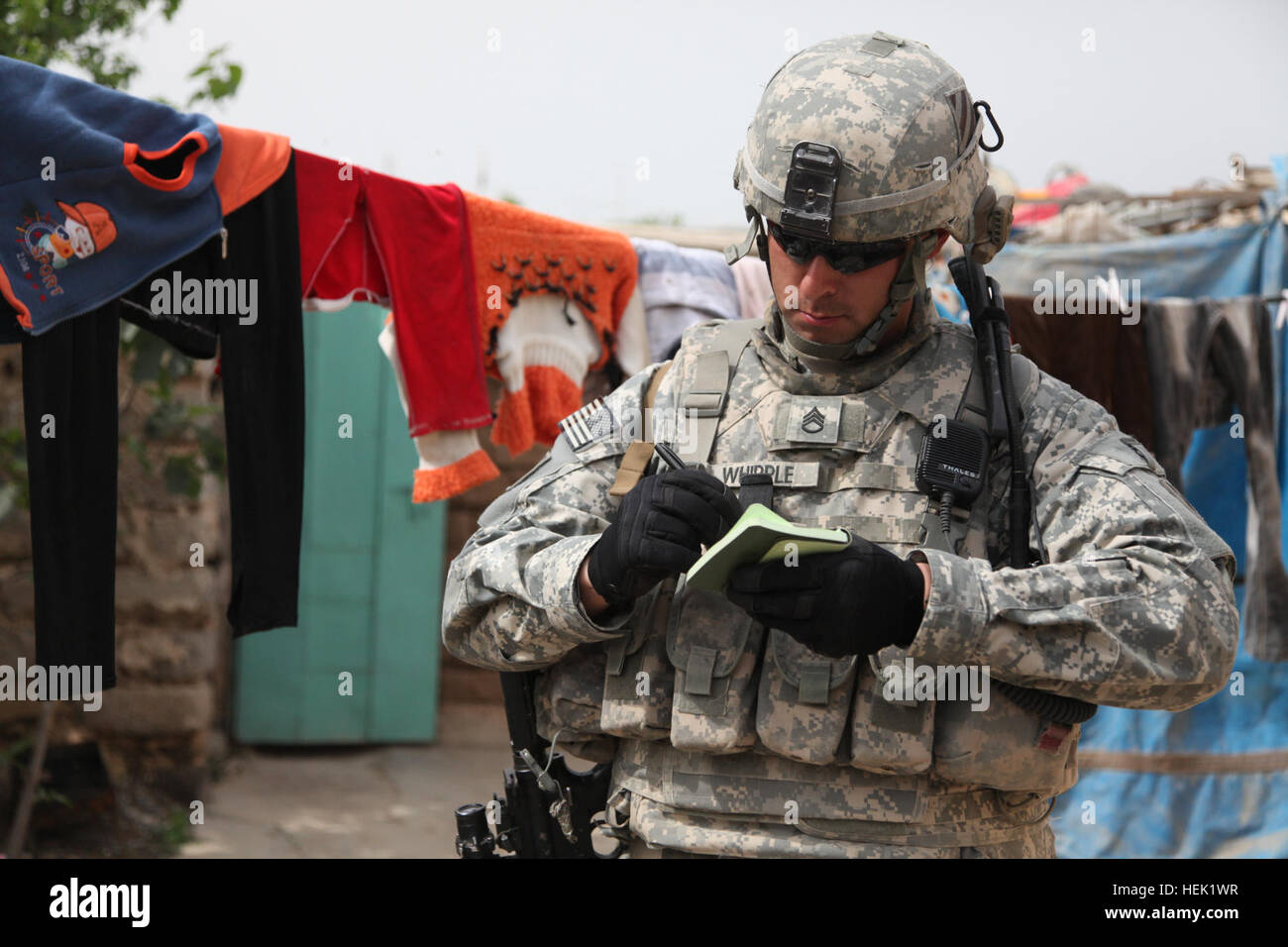 U.S. Army Staff Sgt. John Whipple, Crazy Horse Troop, 3rd Squadron, 7th Cavalry Regiment, 2nd Brigade Combat Team, 3rd Infantry Division, takes notes about a local man in Badoush, Iraq, April 3. Whipple and his team are gathering information about the local populace. Town Assessment 269775 Stock Photo