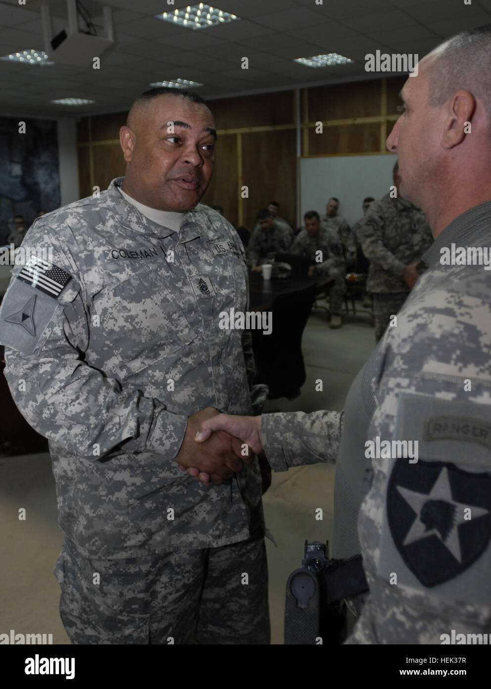 Command Sgt. Maj. Arthur Coleman Jr., the III Corps command sergeant major, shakes the hand of Staff Sgt. Jorge Fabian, a squad leader with Company C, 2nd Battalion, 23rd Infantry Regiment, 4th Stryker Brigade Combat Team, 2nd Infantry Division, during a coin presentation here May 10. Fabian, a Mendoza, Argentina native, received a coin for his determination and commitment to graduating Ranger School and passing his knowledge to lower-enlisted Soldiers in his unit who also hope to attend Ranger School. Ranger graduate receives III Corps CSM coin ... and more 278785 Stock Photo
