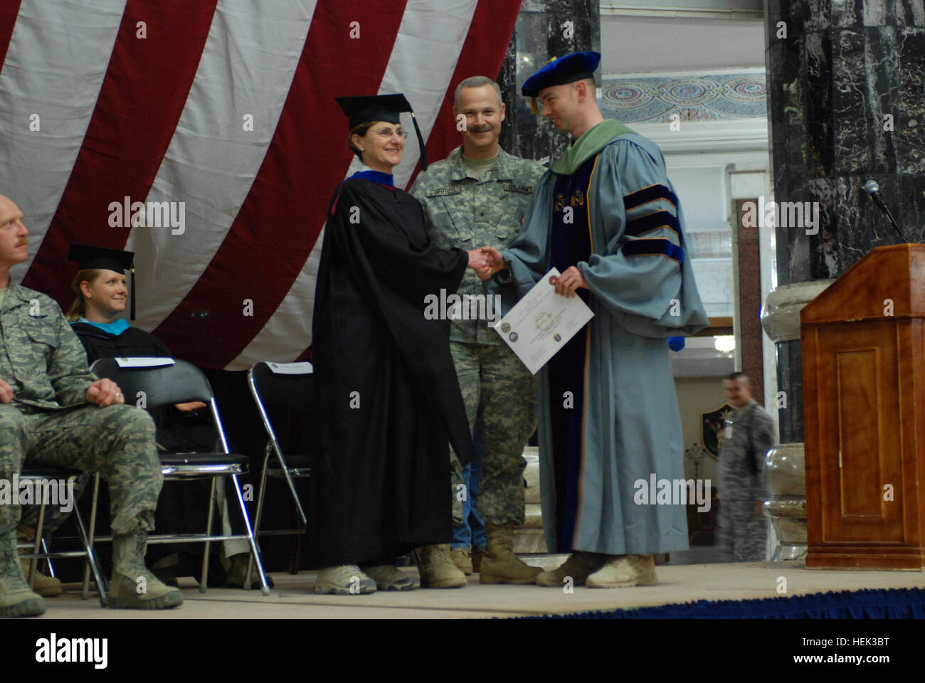 First Lt. John Saindon Jr. (right), medical operations and environmental officer with the 13th Sustainment Command (Expeditionary), and a San Antonio native, receives a Nova Southeastern University doctorate in health science education center certificate May 17 from Brig. Gen. Donald J. Currier (center), commander of the 49th Military Police Brigade, and Carolyn L. Baker (left), chief of continuing education programs, Office of the Secretary of Defense, at Al Faw Palace at Camp Liberty, Iraq. (Photo by: Spc. Britney Bodner) Hard work and humility, environmental officer thrives in Iraq 286323 Stock Photo