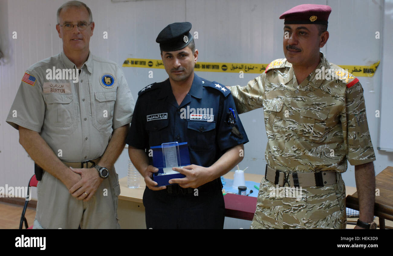 Steven Butler, a mentor, trainer, and advisor, civilian police assistance training team, 1st. Lt. Talib Calvin Hassan, Iraqi police office,, and Maj. Gen. Sabah Al-fatlawi, Iraqi Police commander, Dhi Qar province pose while Hassan receives and award for being an honor graduate of the criminal investigation course during a ceremony held at the Mittica Training Center in Nasiriyah May 20. Ten police officers, each representing various units within Dhi Qar province, accepted their certificates of completion in front of an audience of government officials, their fellow police officers, their fami Stock Photo