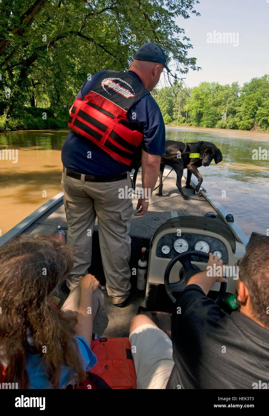 Firefighter Todd Brown, standing, and his bloodhound/ black Labrador search and rescue dog Holly track scents laid out by members of the Department of Homeland Security along the Big Blue River in Edinburgh, Ind., June 4, during the Search and Rescue Conference held at the Camp Atterbury Joint Maneuver Training Center in central Indiana. Brown and Holly work for the New Chapel Fire Department in Floyd County, Indiana. Search and Rescue Dogs Train in Indiana Waters 287976 Stock Photo