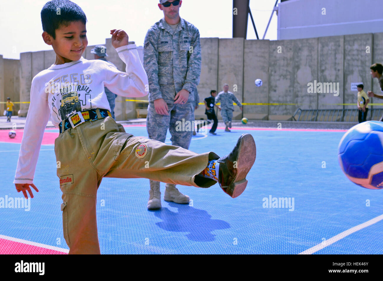 An Iraqi boy kicks a soccer ball around with service members June 19 during Kids Day at Joint Base Balad, Iraq. Service members entertained 77 children, ages 6-14, with American games, food and music. Iraqi kids play American games at Joint Base Balad 294112 Stock Photo