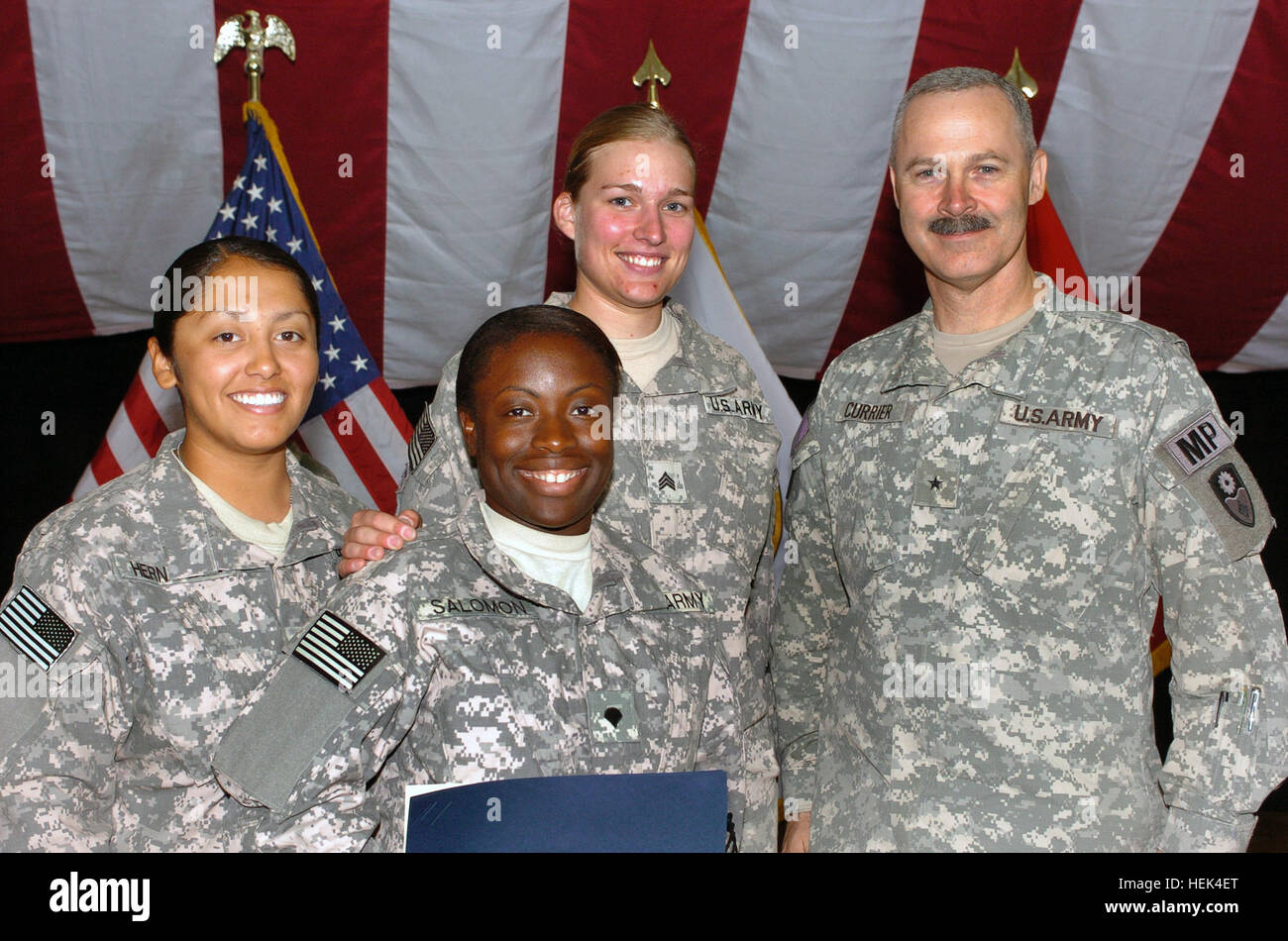 Spc. Glory-Dana Salomon, front, formerly of Haiti, attained her American  citizenship July 4 during a Naturalization Ceremony at Al Faw Palace, Camp  Victory, Iraq. She is flanked by Spc. Veronica Hernandez (left)
