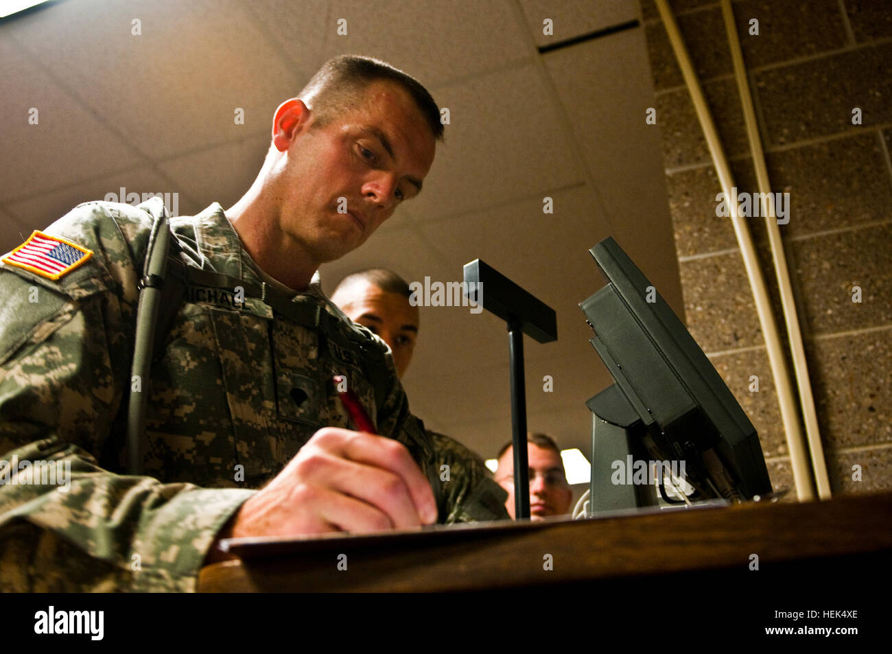 Spc. Derek A. Michael, an Army Reserve Best Warrior competitor and military policeman from Raleigh, N.C., assigned to 535th Military Police Battalion signs a chow roster at Fort McCoy, Wis., July 25, 2010. Michael graduated from Meridian High School in Meridian, Idaho, in 1988. 2010 Army Reserve Best Warrior Competition 303026 Stock Photo