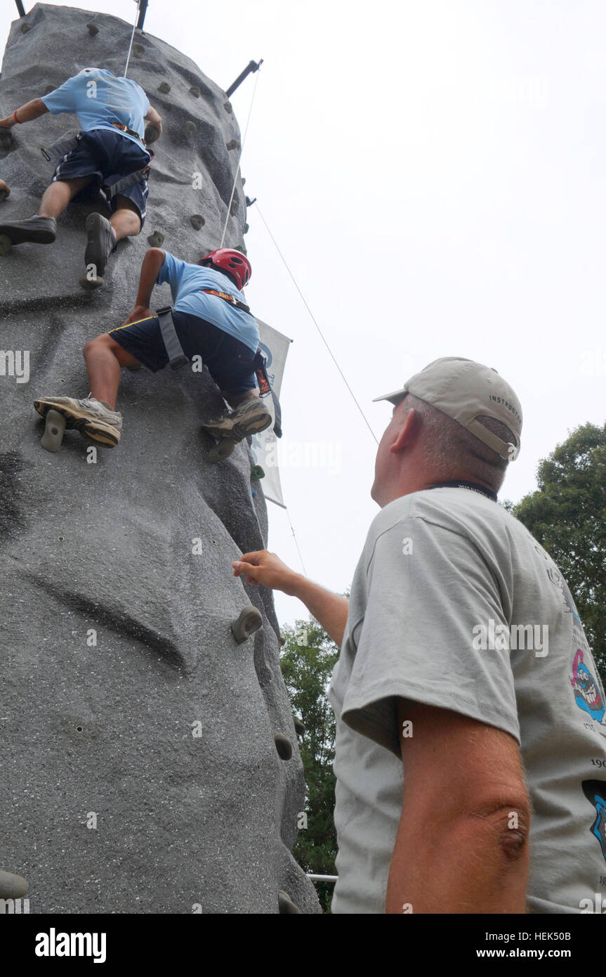 U.S. Army Maj. David Little, 18th Airborne Corps operations analyst from Fort Bragg, N.C., assists Boy Scouts as they ascend the rock climbing wall exhibit during the Boy Scouts of America's 2010 National Scout Jamboree July 27. According to Little, the exhibit can service up to 900 Scouts per day, equaling an approximate 10,000 Scouts over the course of the event. Army Major Helps Scouts Become 'Rock Stars' 304418 Stock Photo
