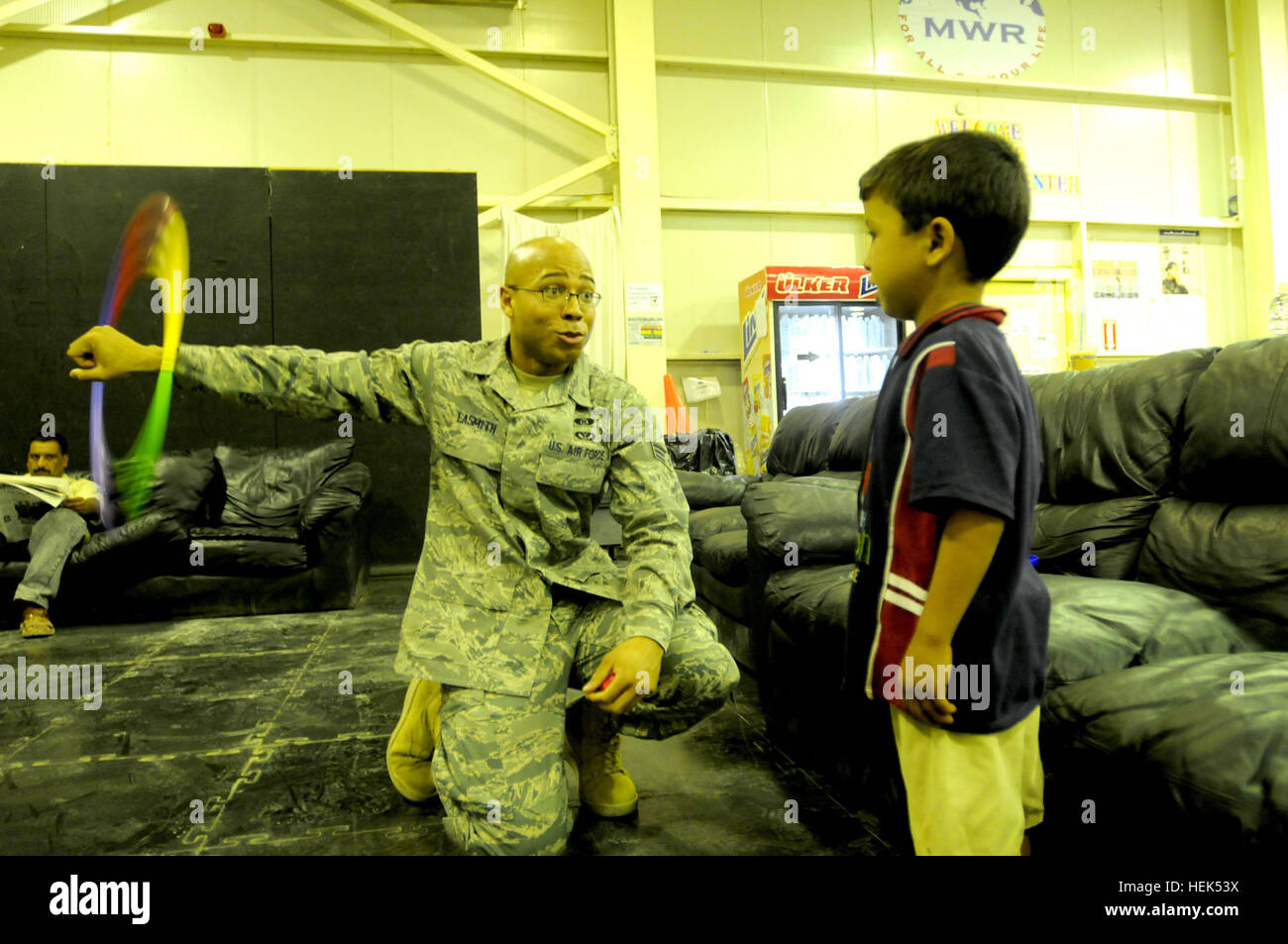 Senior Airment Brandon Lasmith, an emergency manager for the 332nd Expeditionary Civil Engineer Squadron, and a Greensboro, N.C., native, spins a hula-hoop around his arm for an Iraqi boy on July 31 while volunteering for Iraqi Kids Day at Joint Base Balad, Iraq. This monthly event allows children to come on the base to interact with U.S. Forces in a non-hostile enviroment. Iraqi Kids Day 307257 Stock Photo