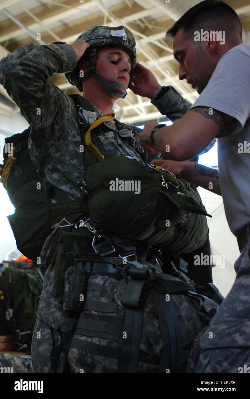 A 2nd Brigade Combat Team Jumpmaster insects a Paratrooper's harness at