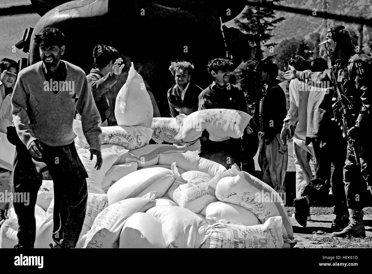 Local Pakistanis unload sacks of flour delivered by a TF Denali CH-47 Chinook helicopter to Kalam, a landing zone in flood-affected Swat valley, Khyber Pakhtunkhwa province, Pakistan. 'Sugar Bears' in Pakistan, on 'flight' and 'helping people' 338400 Stock Photo