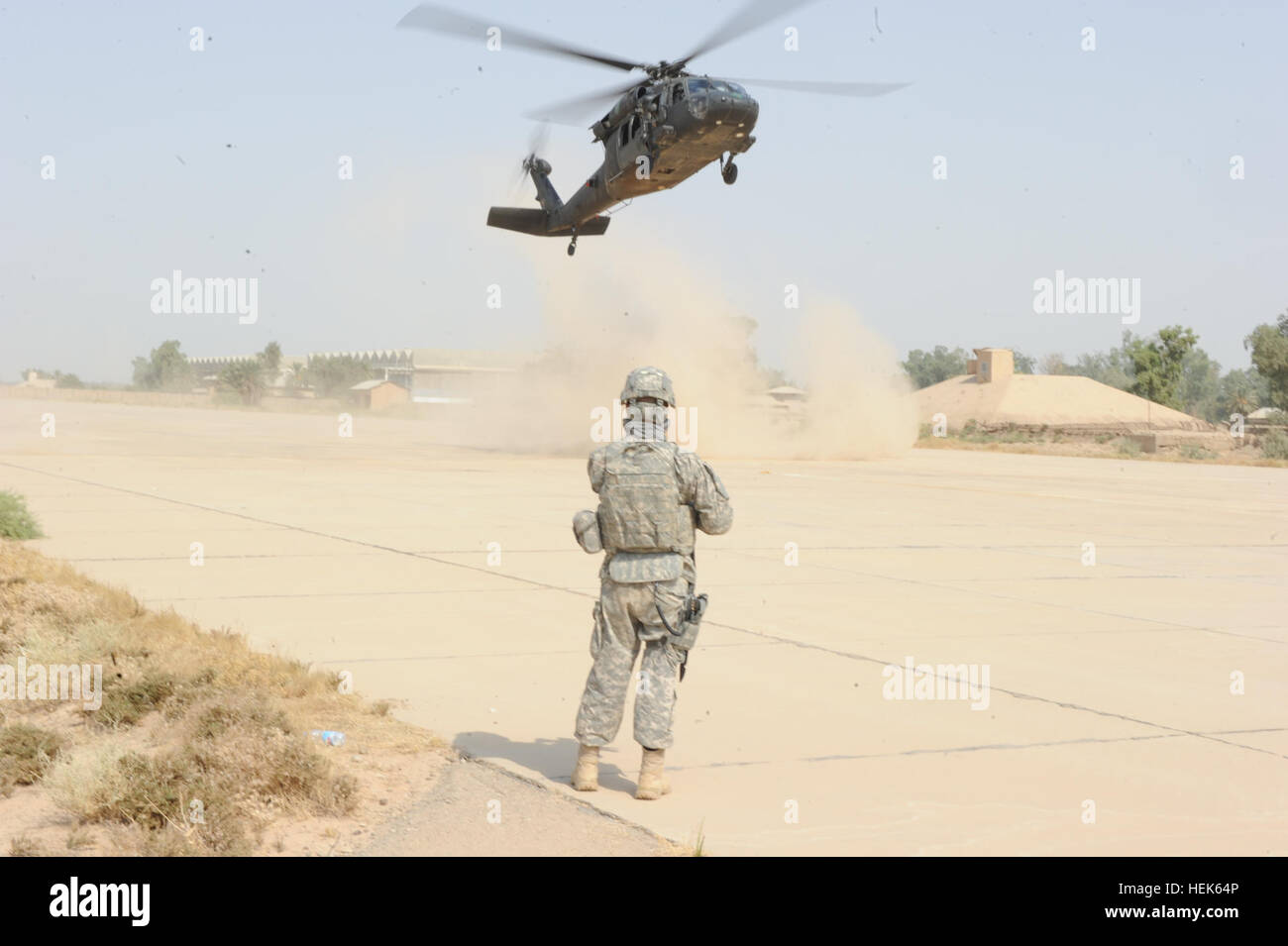 U.S. Army Spc. Clark Sponable with 442d Military Police Company, N.Y. National Guard provides security as U.S. Army Brig. Gen. Kenneth Tovo, deputy commander, with United States Division - Central lands in UH-60 Black Hawk outside the Police Training Center in Habbaniyah, Iraq, Sept. 23. Tovo and U.S. soldiers with 442nd MP Company participated in a brief tour of the Police Training facility. Iraqi Police Training Center Tour 331352 Stock Photo