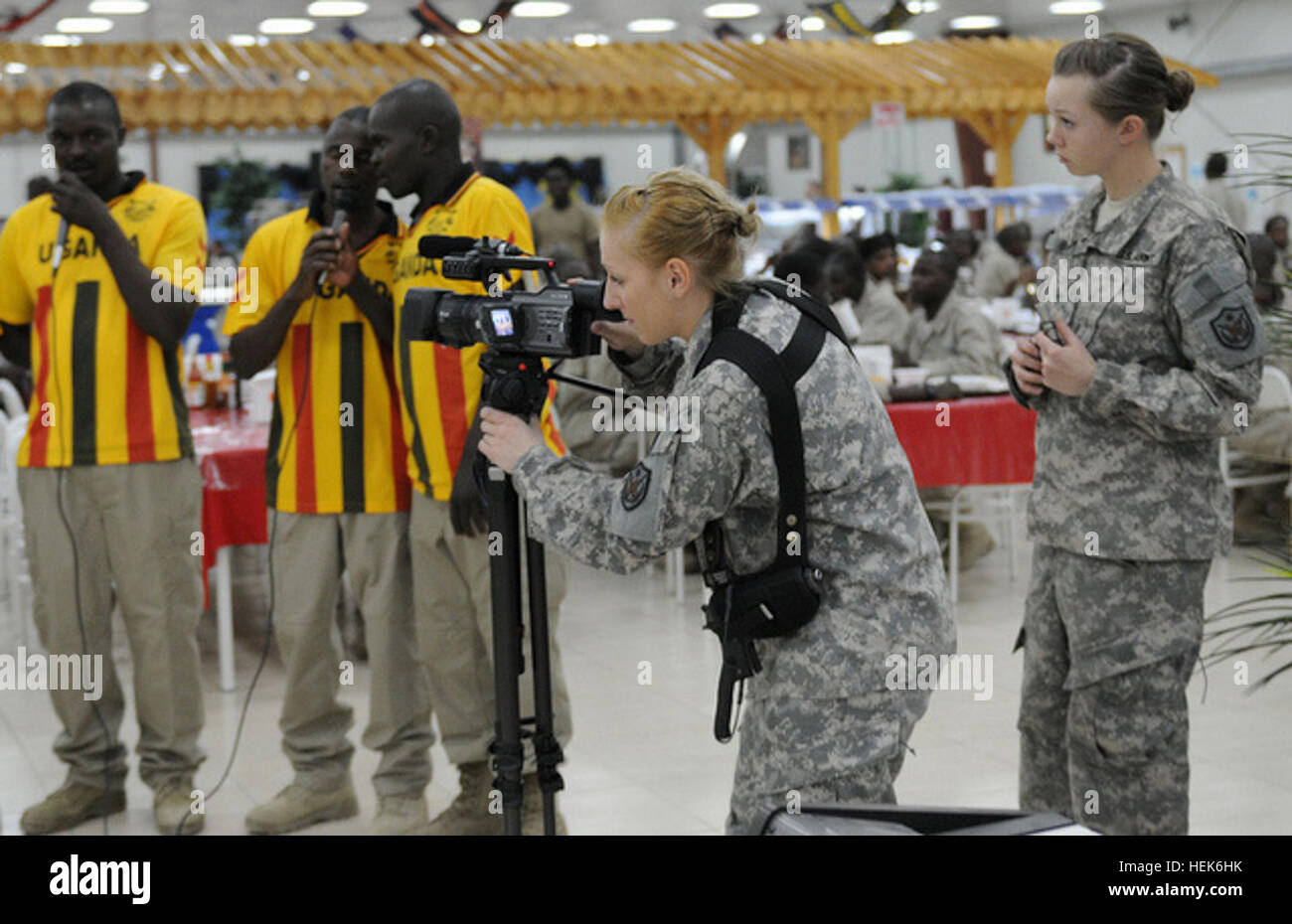 Pvt. 1st Class Meghan Berry (Now Sgt. Meghan Berry), broadcast specialist, 10th Press Camp Headquarters, looks on as Spc. Elizabeth Gerhart, broadcast specialist, 10th PCH, captures footage of a Ugandan Independence Day celebration , Forward Operating Base Prosperity, Baghdad, Oct. 9, 2010. Public affairs soldiers needed more than ever 101009-A-AA123-001 Stock Photo