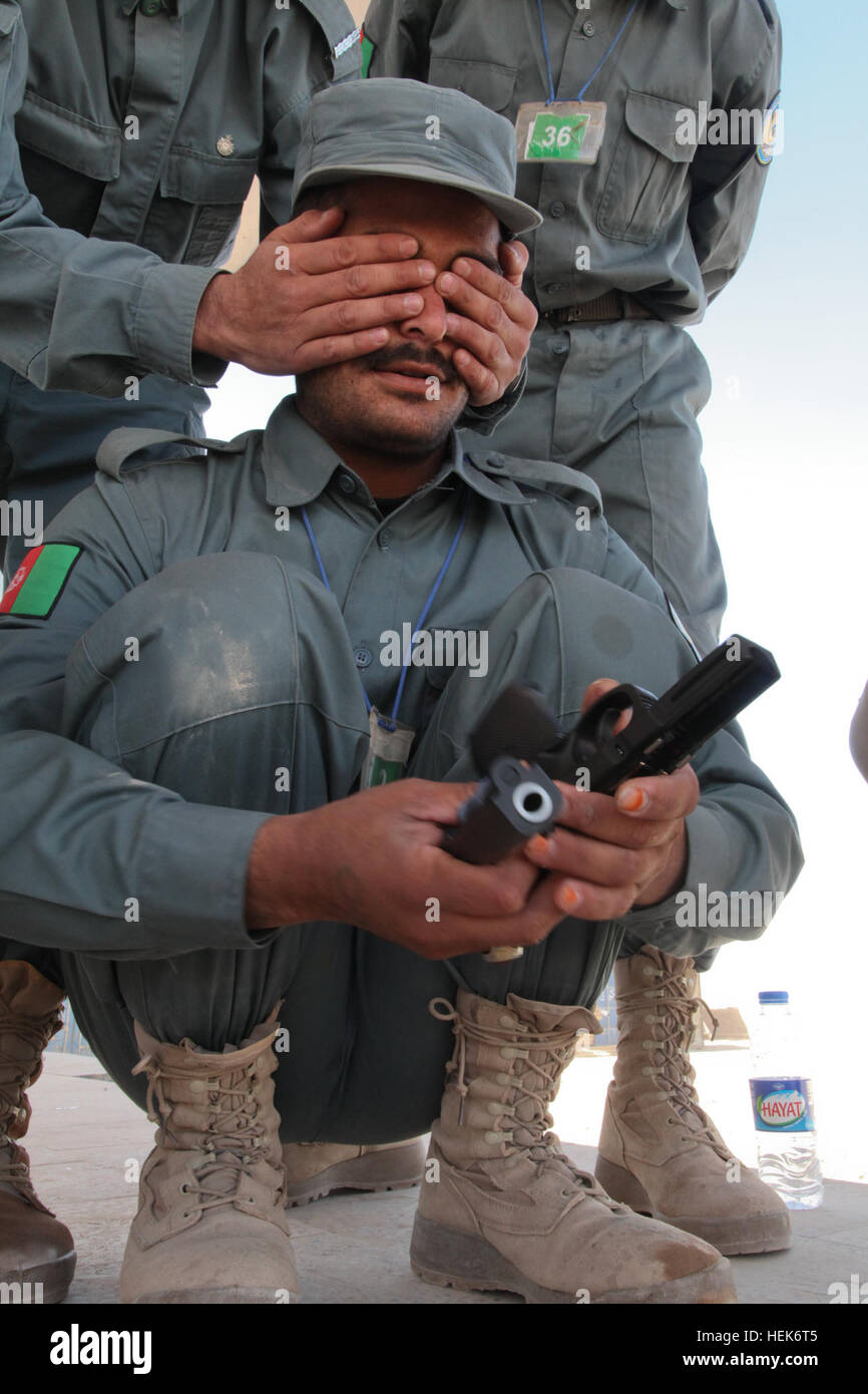 An Afghan National Police student tests his skills in assembling and disassembling an M9 pistol during a class at Forward Operating Base Tirin Kot, Uruzgan province, Afghanistan, Oct. 21, 2010. The students trained in various handling and firing positions. (U.S. Army photo by Spc. Kaitlin M. Joiner/Released) M9 pistol during a class 101021-A-SP903-044 Stock Photo