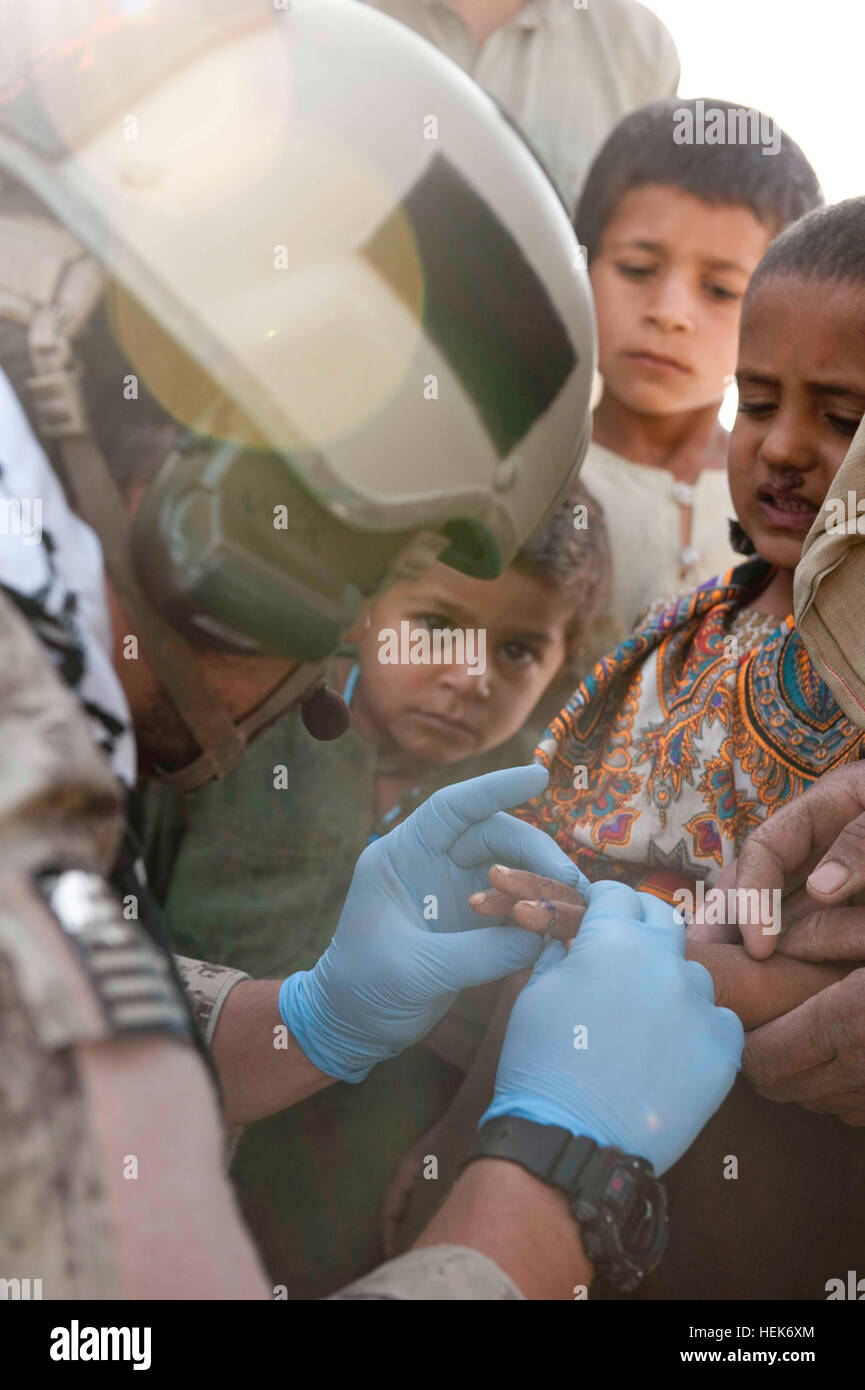 A U.S. Special Forces medic treats a neglected gash on the hand of an ...