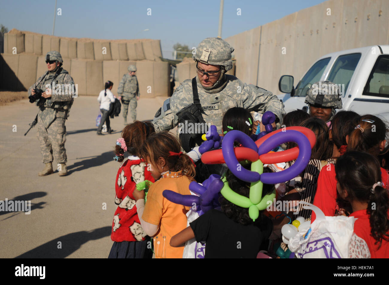 Spc. John Romansky, Combat Engineer, 229th Multiple Role Bridge Company, 36th Engineer Brigade, hands out sandals as part of 'Operation Flip Flop' to Iraqi children during Iraqi Kids Day on Joint Base Balad. Iraqi Kids Day, Operation Flip-Flop 340113 Stock Photo