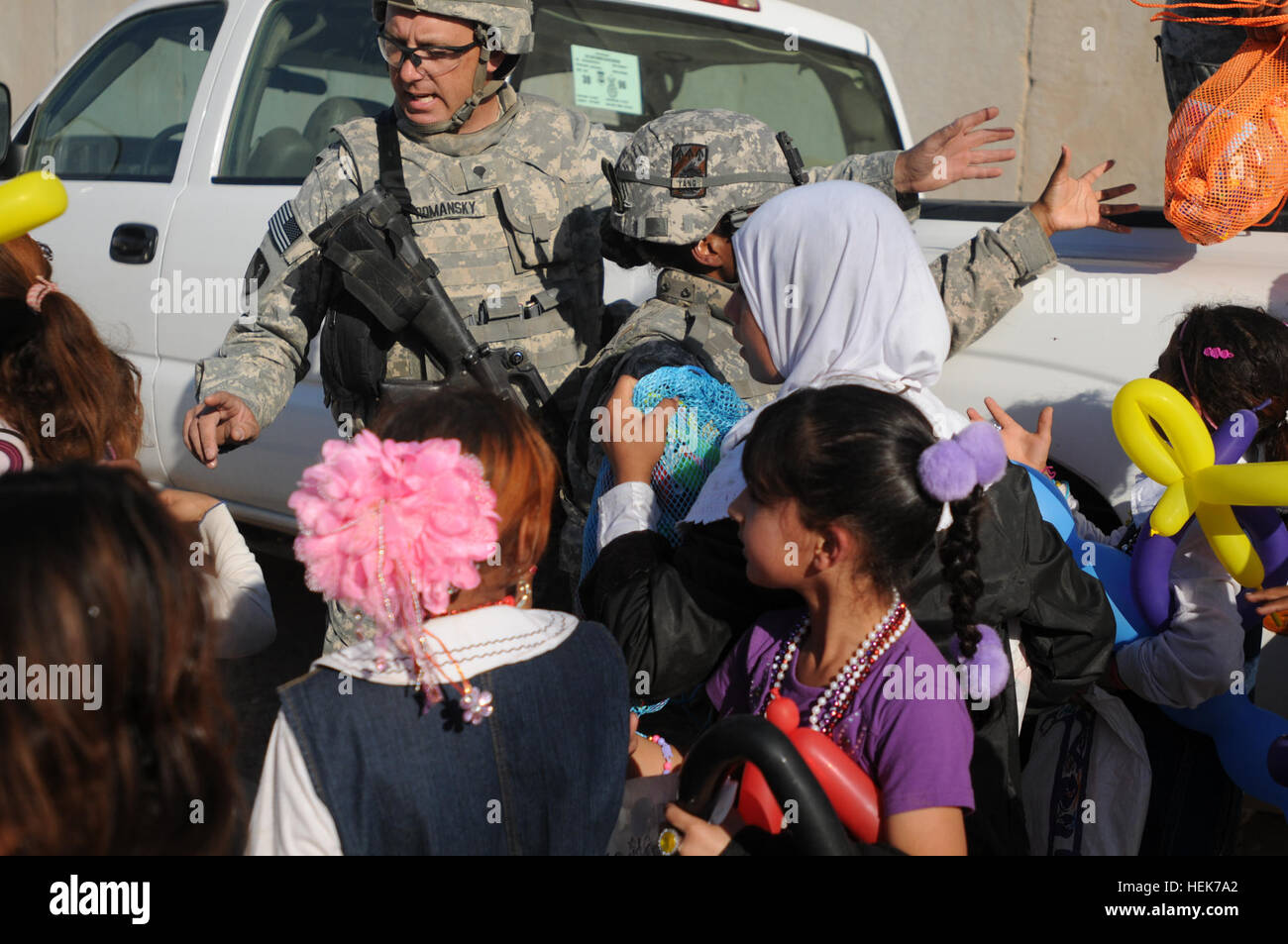 Spc. John Romansky, Combat Engineer, 229th Multiple Role Bridge Company, 36th Engineer Brigade, hands out sandals as part of 'Operation Flip Flop' to Iraqi children during Iraqi Kids Day on Joint Base Balad. Iraqi Kids Day- Operation Flip-Flop 340112 Stock Photo