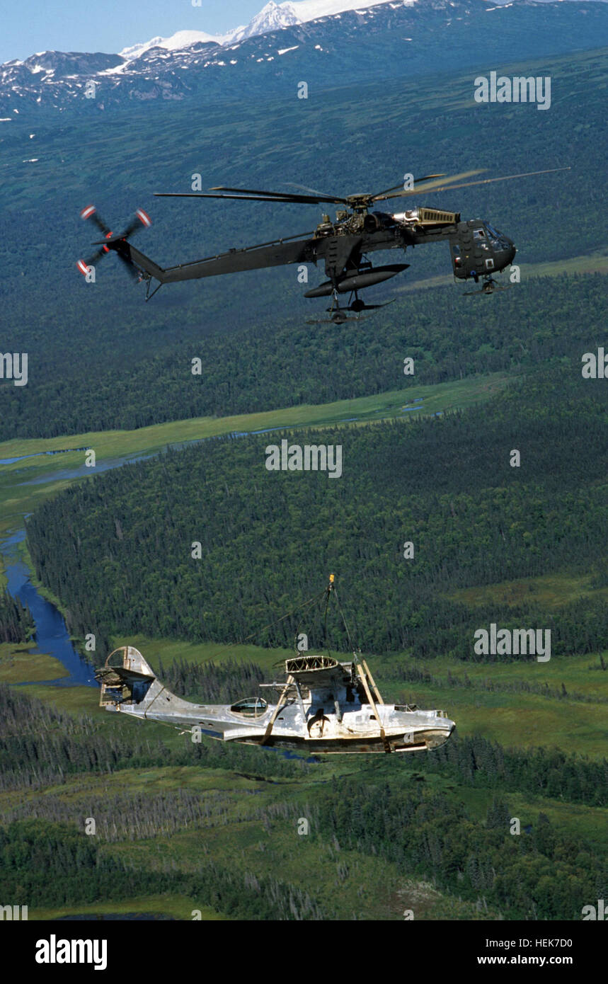 An Alaska Army National Guard CH-54B Tahre airlifts an OA-10 PBY Catalina flying boat while departing Lake Clark Pass during a recovery operation.  The historic aircraft was abandoned by the Air Force after engine trouble forced it down at Dago Lake on September 30, 1947.  Members of the Alaskan Aviation Heritage Museum, initiators of the recovery operation, plan to restore the aircraft and have it flying again sometime in the early 1990s. CH-54 with OA-10A wreck1 in Alaska 1987 Stock Photo