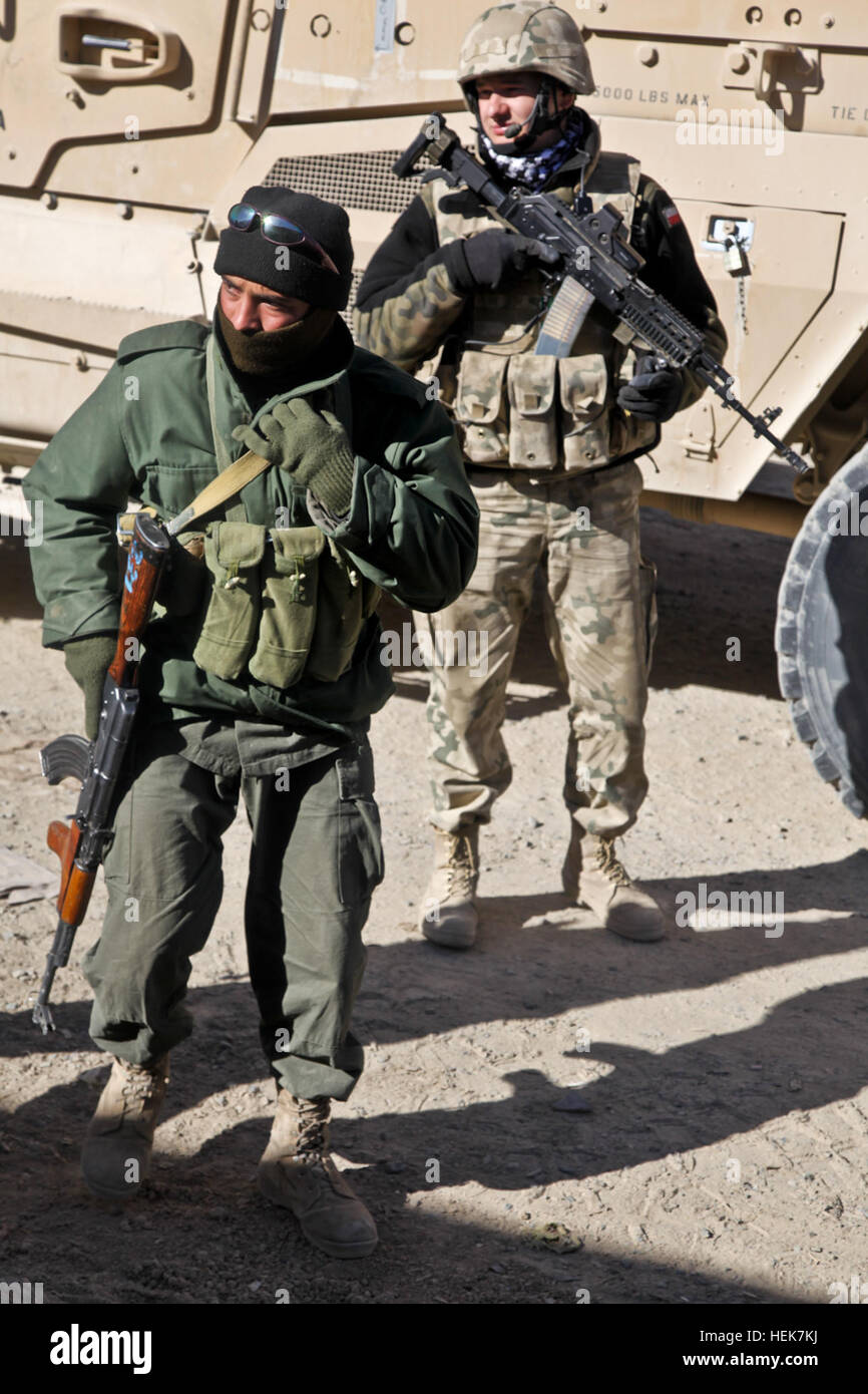 An Afghan National soldier advances the patrol while a Polish soldier pulls security in the city of Ghazni, Afghanistan. Afghan troops, and uniformed police are stepping up their involvement and taking a more active role in the security and stability of Afghanistan, Operation Enduring Freedom, Nov. 20. (U.S. Army photo by Sgt. Justin Howe) Patrol in Ghazni 343065 Stock Photo