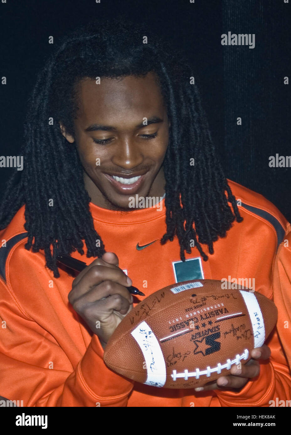 FORT BLISS, Texas (December 27, 2010) A University of Miami football player signs a football at Freedom Crossing at Fort Bliss, the post's new post exchange complex, Dec. 27. While both the Hurricanes and University of Notre Dame football players were poised to formally visit Bliss the following day, the Atlantic Coast Conference member school came early to mingle with Army families as part of their Sun Bowl and El Paso experience. The two teams will face off in the 2010 Hyundai Sun Bowl Dec. 31.  Photo by David Poe. Soldiers meet football players 353618 Stock Photo