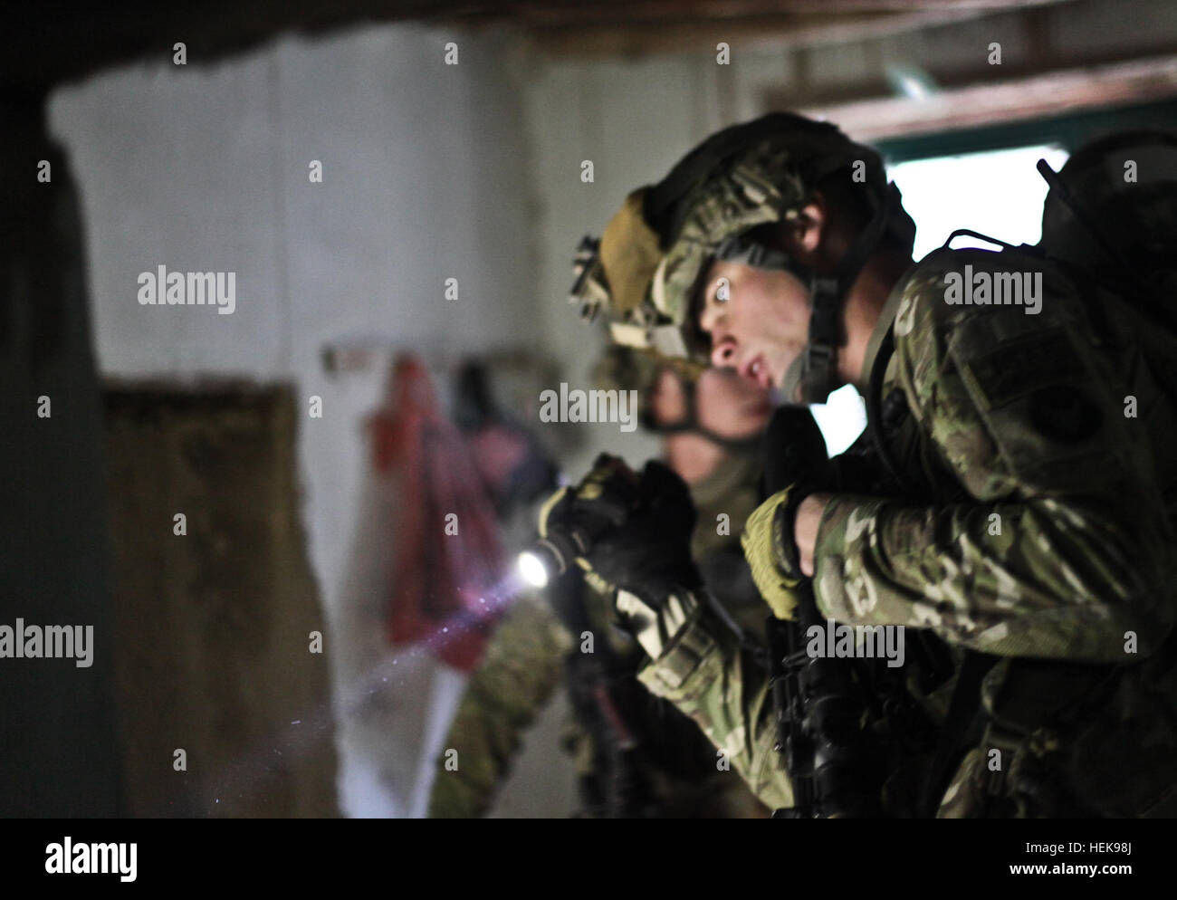 LAGHMAN PROVINCE, Afghanistan - U.S. Army Staff Sgt. Jeff Behan, an infantry squad leader with Company C, 1st Battalion, 133rd Infantry Regiment, from Sabula, Iowa, searches through a room in the residence of a high-value target during Operation Brass Monkey, Feb. 19 outside Parwai, Afghanistan. The Red Bulls Soldiers, teamed with Afghan National Army Soldiers, were unable to nab the high-value target, but did detain six other persons of interest and were also able to locate possible improvised explosive device-making materials, as well as some other key pieces of information/evidence regardin Stock Photo