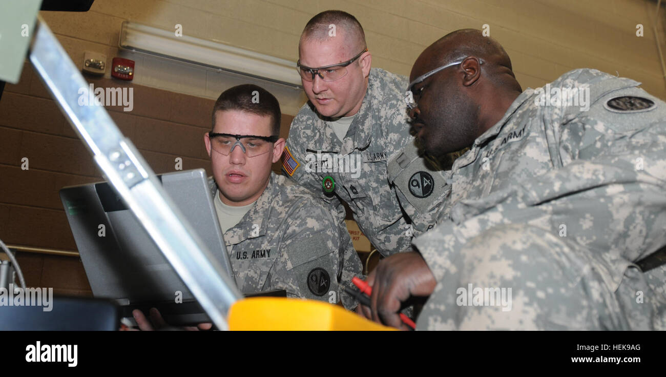 From L-R, Staff Sgt. Joshua Bryant, Sgt. 1st Class Michael Merrit, both instructors at Regional Training Site-Maintenance Fort Indiantown Gap, and Sgt. George Plight, a student from 1729th Forward Support Medical Company reference the wiring diagram of a 3 kilowatt generator on a computer during a trouble shooting class at RTS-M FIG, Pa., Jan. 10, 2013. Powering up the students at Regional Training Site-Maintenance Fort Indiantown Gap 110223-A-KD890-571 Stock Photo