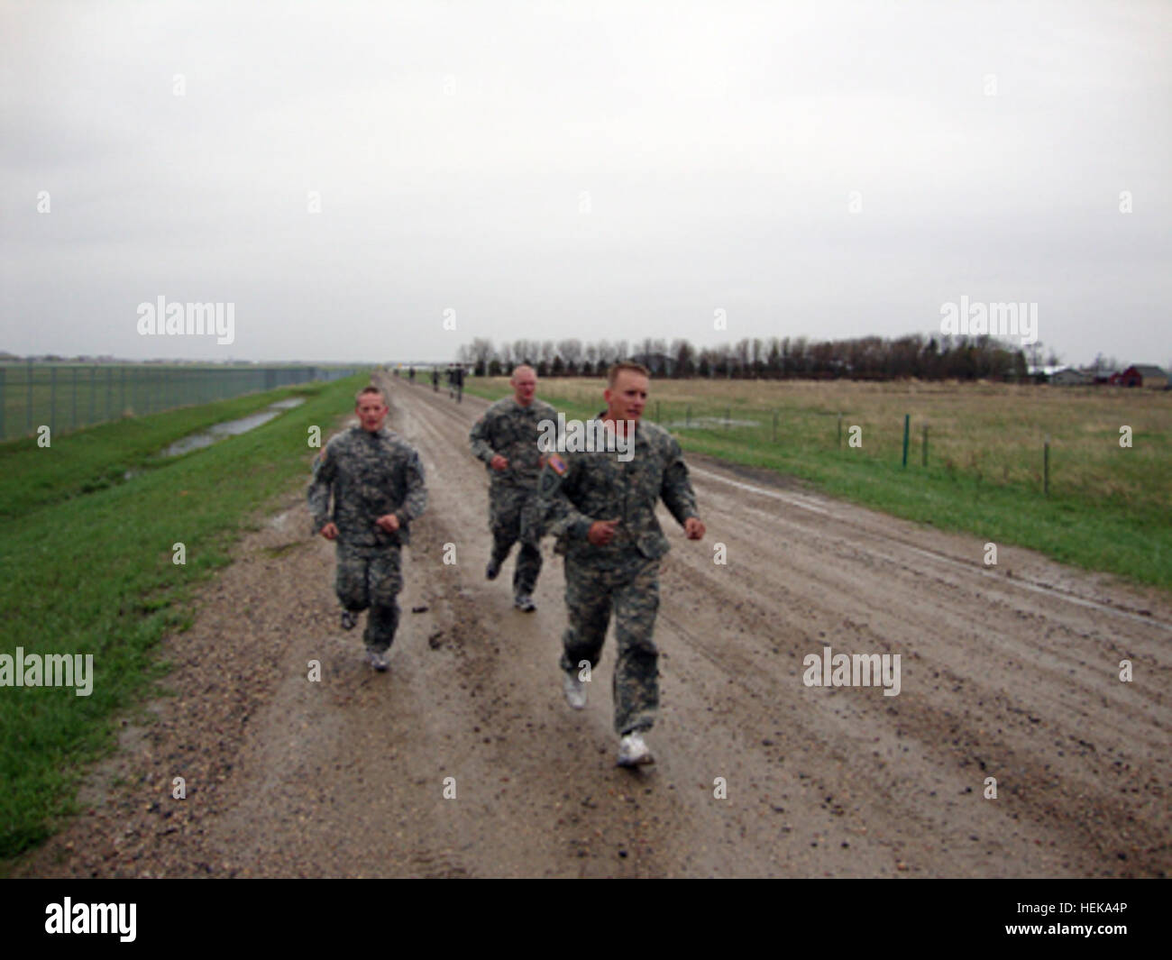 Pfc. John Thorenson II, of Fessenden, N.D., pulls ahead of Spc. Scott Jenson, of East Grand Forks, Minn., and Spc. Andrew Swiontek, of Fargo, N.D., during a two-mile run on May 14 near the Fargo Armed Forces Reserve Center. The Soldiers serve in the North Dakota National Guard’s 191st Military Police Company and took part in tryouts for a chance to attend Air Assault school. (Photo by Spc. Daniel Carpenter) ND Soldiers Challenge Selves to Qualify for Air Assault School 403705 Stock Photo
