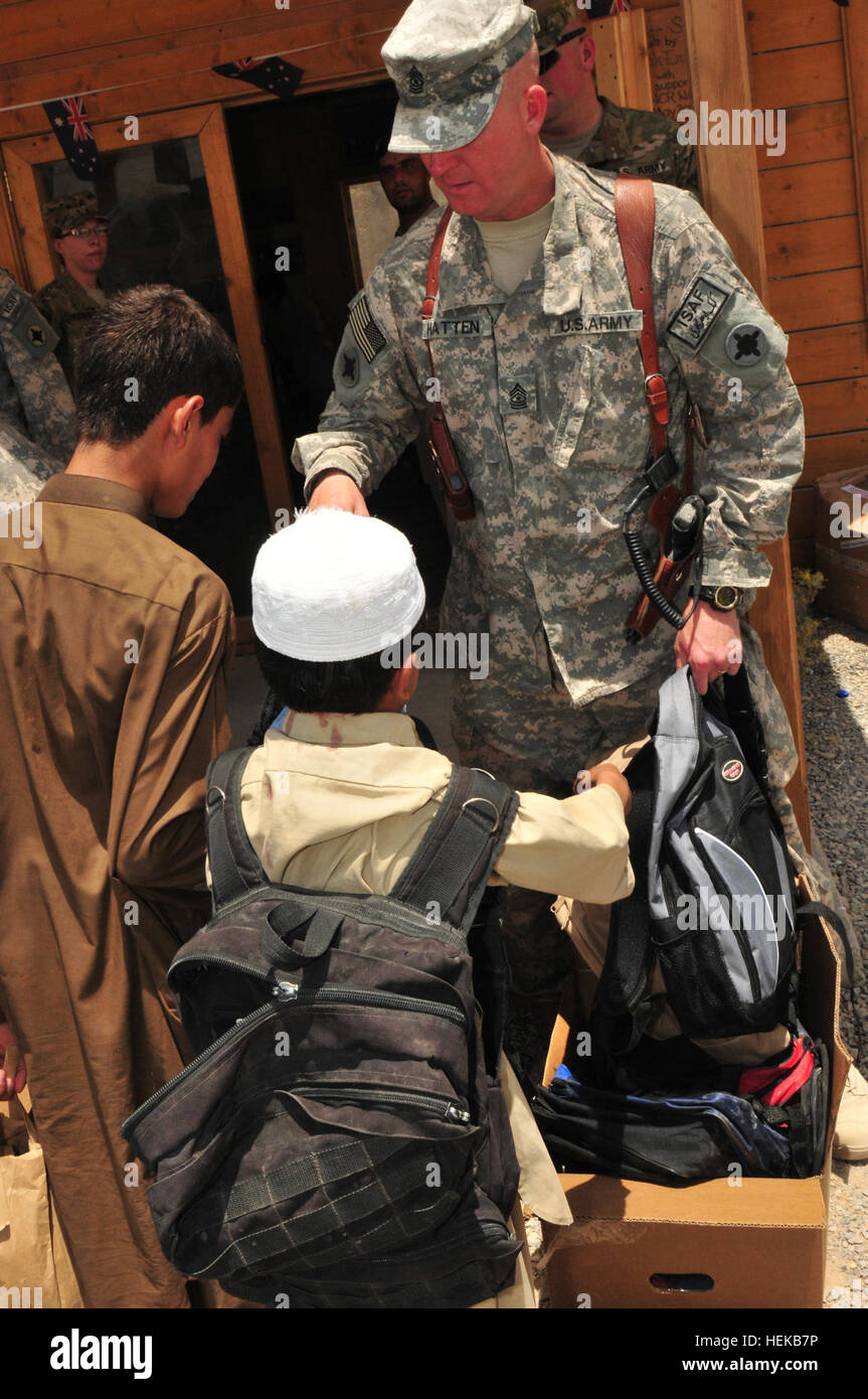 U.S. Army Sgt. Maj. William Hatten, Joint Sustainment Command–Afghanistan operations sergeant major, passes out backpacks filled with school supplies to local Afghan children attending the Kandahar Airfield Bazaar School June 25. Hatten is a member of the Mississippi Army National Guard’s 184th Expeditionary Sustainment Command, which has been deployed to Afghanistan in support of Operation Enduring Freedom since early October. The school supplies were provided through a unique collaboration between Mid Gulf Forestry Inc. and students from Parklane Academy in McComb, Miss. Mississippi Army Nat Stock Photo