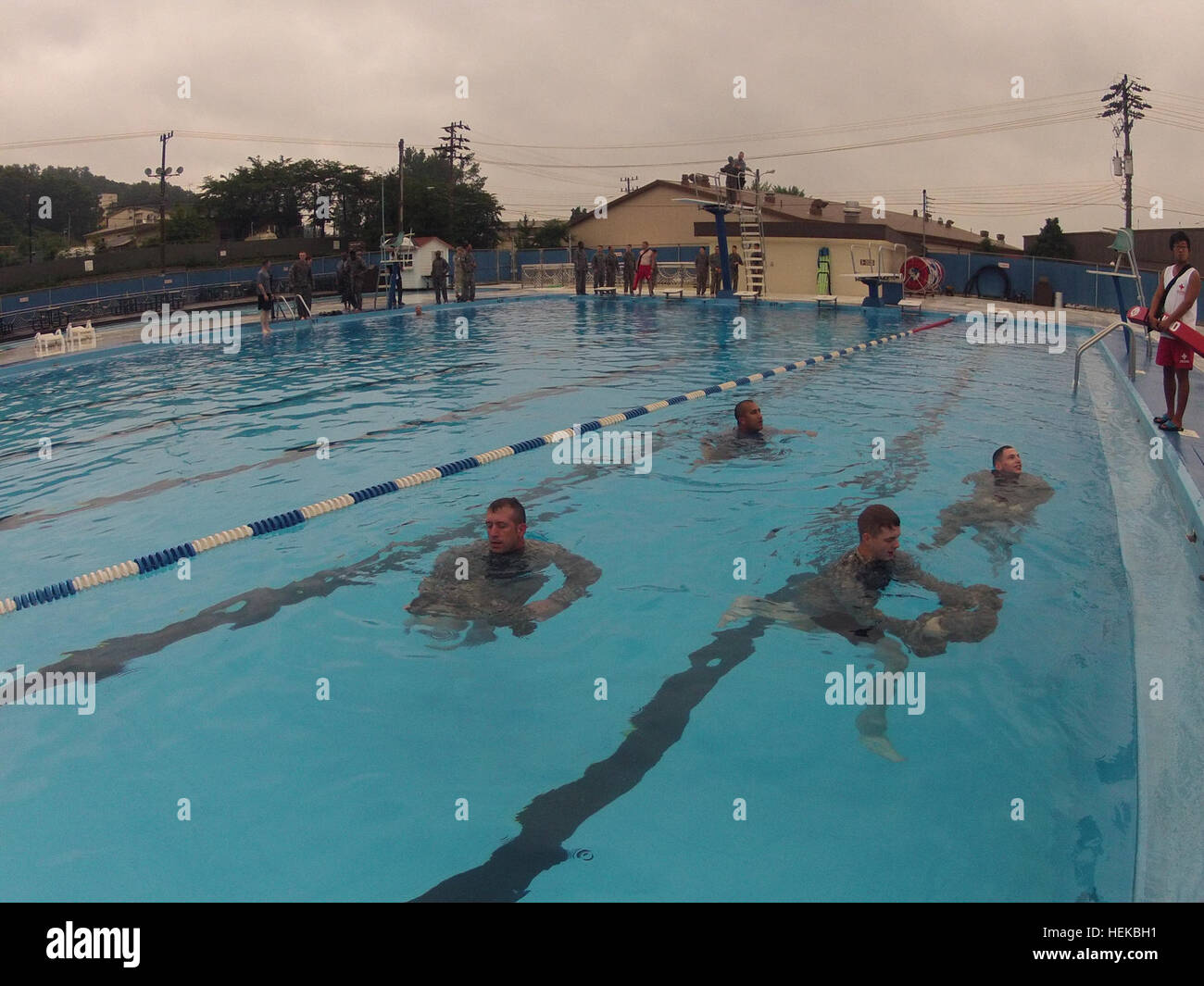 U.S. Soldiers assigned to Headquarters and Headquarters Battery, 210th Fires Brigade, 2nd Infantry Division, remove their uniforms in the water to inflate and increase buoyancy during Combat Water Survival Training at Hanson pool, Camp Casey, South Korea, July 12, 2013. The unit trained its Soldiers for all possible situations to be prepared to defend the Republic of Korea from any threat.  (U.S. Army photo by Cpl. Kim Han-byeol/Released) Combat Water Survival Training 130712-A-WG463-109 Stock Photo