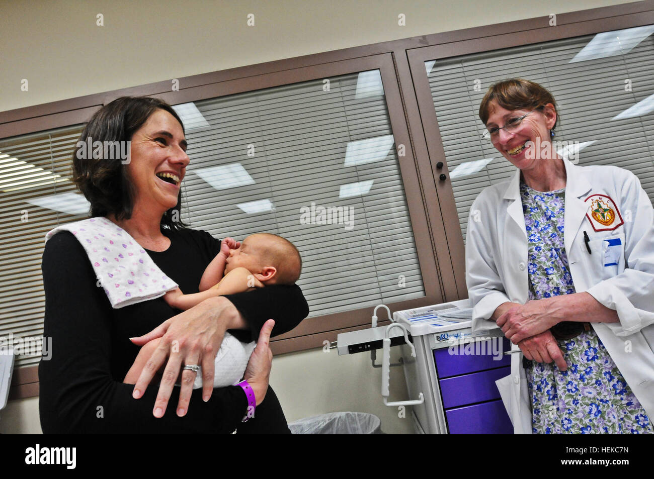 Jenn Hemmer (left) - her 4-week-old daughter, Riley, in her arms - speaks with pediatrician Elizabeth Hasert Aug. 2 at Madigan Army Medical Center on Joint Base Lewis-McChord, Wash., about healthy baby weights during one of the hospital's Moms Own Milk group sessions. MOMs group is a twice-weekly organized effort by the MAMC lactation consultant office to bring breastfeeding mothers together with staff members who provide education on the topic, support, weigh-ins and advice concerning every aspect of breastfeeding. 'A special kind of bond,' Amidst World Breastfeeding Week, group offers new JB Stock Photo