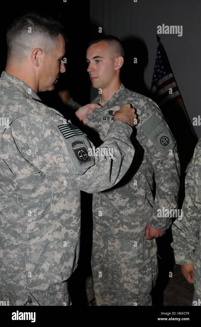 Pfc. Brain J. Roth, a vehicle driver assigned to A Company, 2nd Battalion, 407th Brigade Support Battalion of the 82nd Airborne Division's 2nd Advise and Assist Brigade is awarded the Combat Action Badge from brigade commander, Col. Tim McAteer, at Al-Asad Air Base, Iraq, Aug. 16. Roth earned the CAB for his actions during roadside bomb attack on his armored vehicle while on a unit resupply mission. The spirit of warrior ethos 444179 Stock Photo