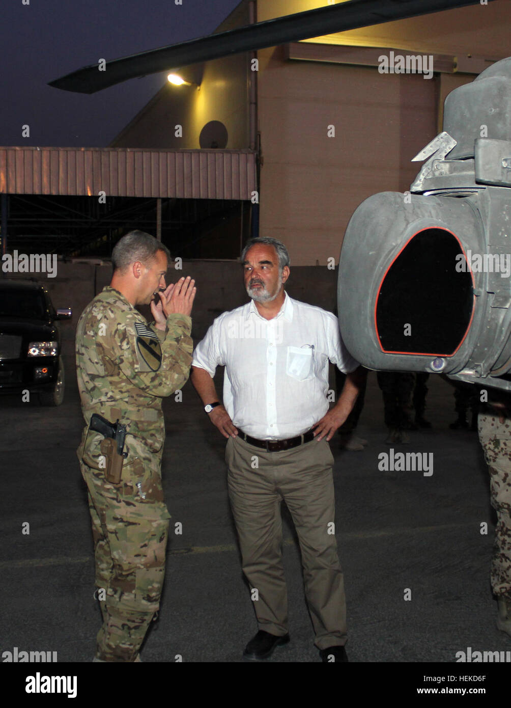 CAMP MARMAL, Afghanistan -- Sec. Thomas Kossendey, Germany’s deputy defense minister, talks with Lt. Col. William Huff, commander, Task Force Lobos, 1st Air Cavalry Brigade, 1st Cavalry Division, about the intricacies of the AH-64D Apache attack helicopter Aug. 31. The 1st ACB is currently conducting combat operations in Regional Command North, which is led by the Germans. (U.S. Army photo by Staff Sgt. Joe Armas, 1st ACB, 1st Cav. Division Public Affairs) Thomas Kossendey Camp Marmal Afghanistan 2011 Stock Photo