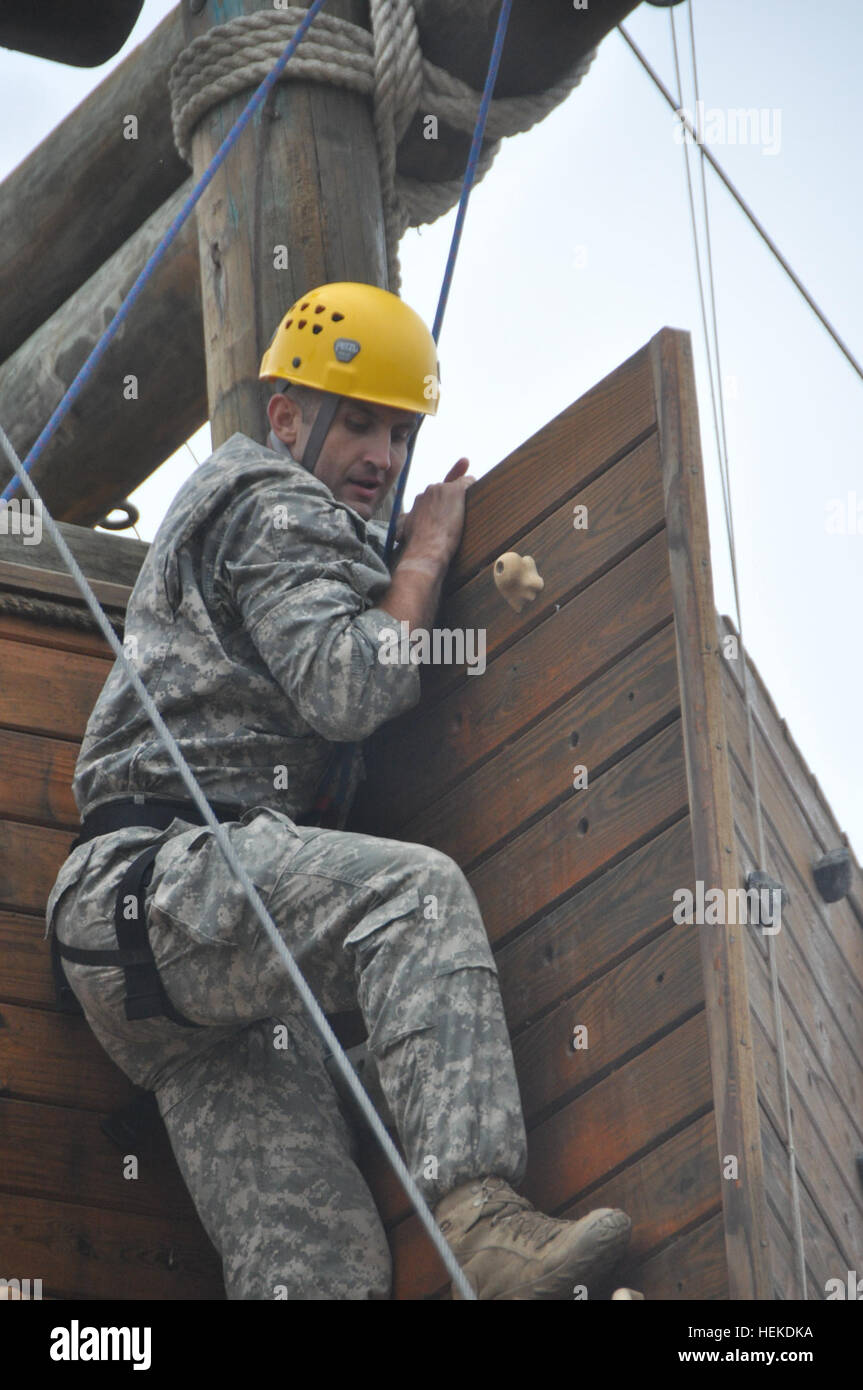 Sgt. Jose Alves of Riverbank, Calif., a combat medic with the 79th Infantry Brigade Combat Team, reaches the top of the towering rock wall at Camp San Luis Obispo, Calif., Sept. 15, 2011 as part of the Best Warrior Competition. The nine competitors spent the morning racing through a lengthy obstacle course before climbing the tower, which was a timed event. California National Guard soldiers compete to become the 2011 Best Warrior 110915-A-DH635-002 Stock Photo