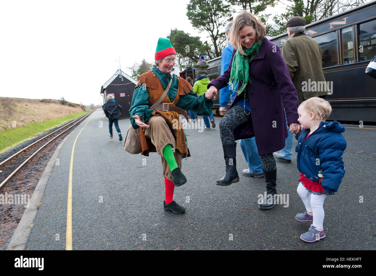 Rhyd Ddu, Gwynedd, Snowdonia National Park, Wales, UK. 22nd, December, 2016. One of Santa's Elves amuses a young child on the platform at Rhyd Ddu station. The Santa train - Caernarfon to Rhyd Ddu - is seen at the turn around point at Rhyd Ddu. The Steam locomotive is Beyer-Garratt made in Manchester in 1958 and shipped to South Africa. © Graham M. Lawrence/Alamy Live News. Stock Photo