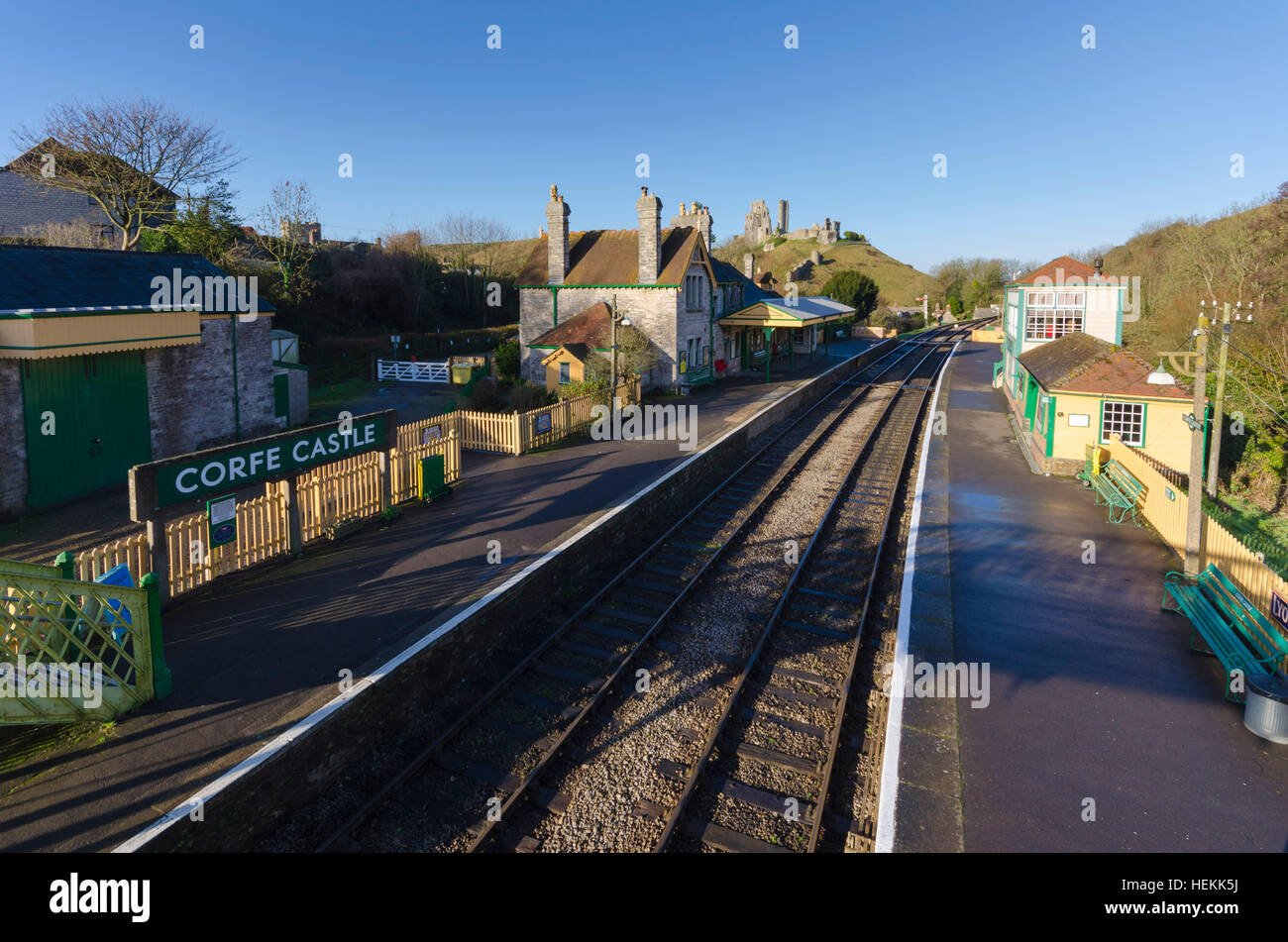 Corfe Castle, Dorset, UK. 22nd December 2016. UK Weather. Corfe Castle station in Dorset on the restored Swanage Railway basking under clear sunny blue skies. The footbridge across the tracks is a perfect vantage point to view the ruins of the castle which give the village its name. Picture: Graham Hunt/Alamy Live News Stock Photo