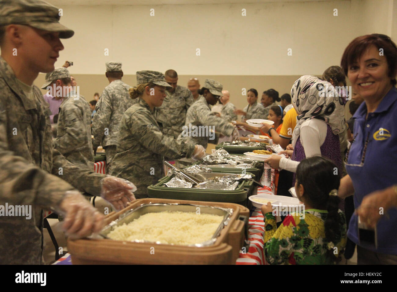 U.S. Army soldiers and U.S. Air Force airmen serve food to Iraqi children during Iraqi Kids' Day at Joint Base Balad in Salah Aldin province, Iraq, Oct. 1, 2011. The purpose of Iraqi Kids' Day is to build positive relations with Iraqi children, let them know that the U.S. forces in Iraq are friendly and are here to help the well-being of Iraq's citizens. All these soldiers and airmen are in Iraq in support of Operation New Dawn. (Photo by Pfc. Nikko-Angelo Matos) Iraqi Kids' Day 111001-A-YV529-082 Stock Photo