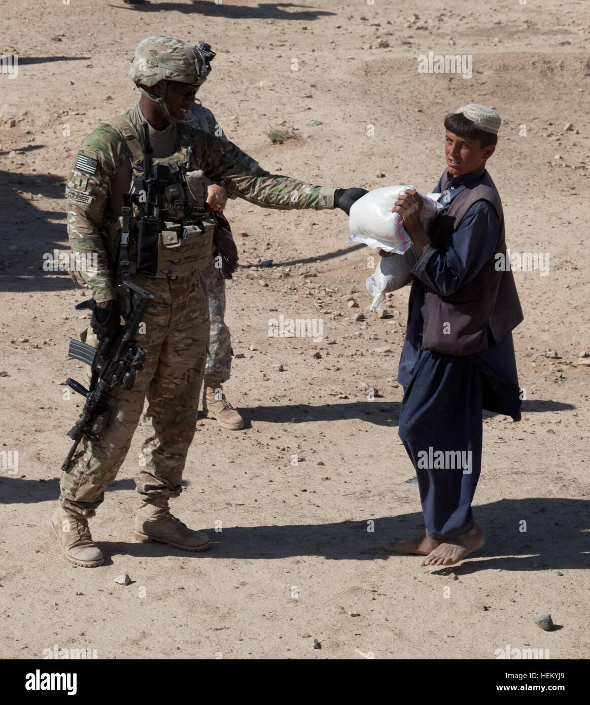 U.S. Army 1st Lt. John Collier, left, from 504th Battlefield Surveillance  Brigade, hands out food to an Afghan boy in Ulagay, Kandahar province,  Afghanistan, Oct. 19, 2011. Soldiers of 504th Battlefield Surveillance