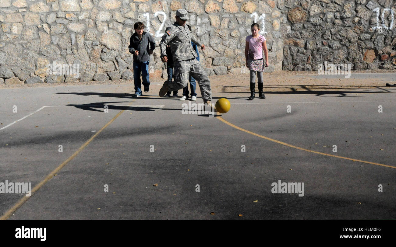 U.S. Army Staff Sgt. Juan Valdez plays kickball with students during a