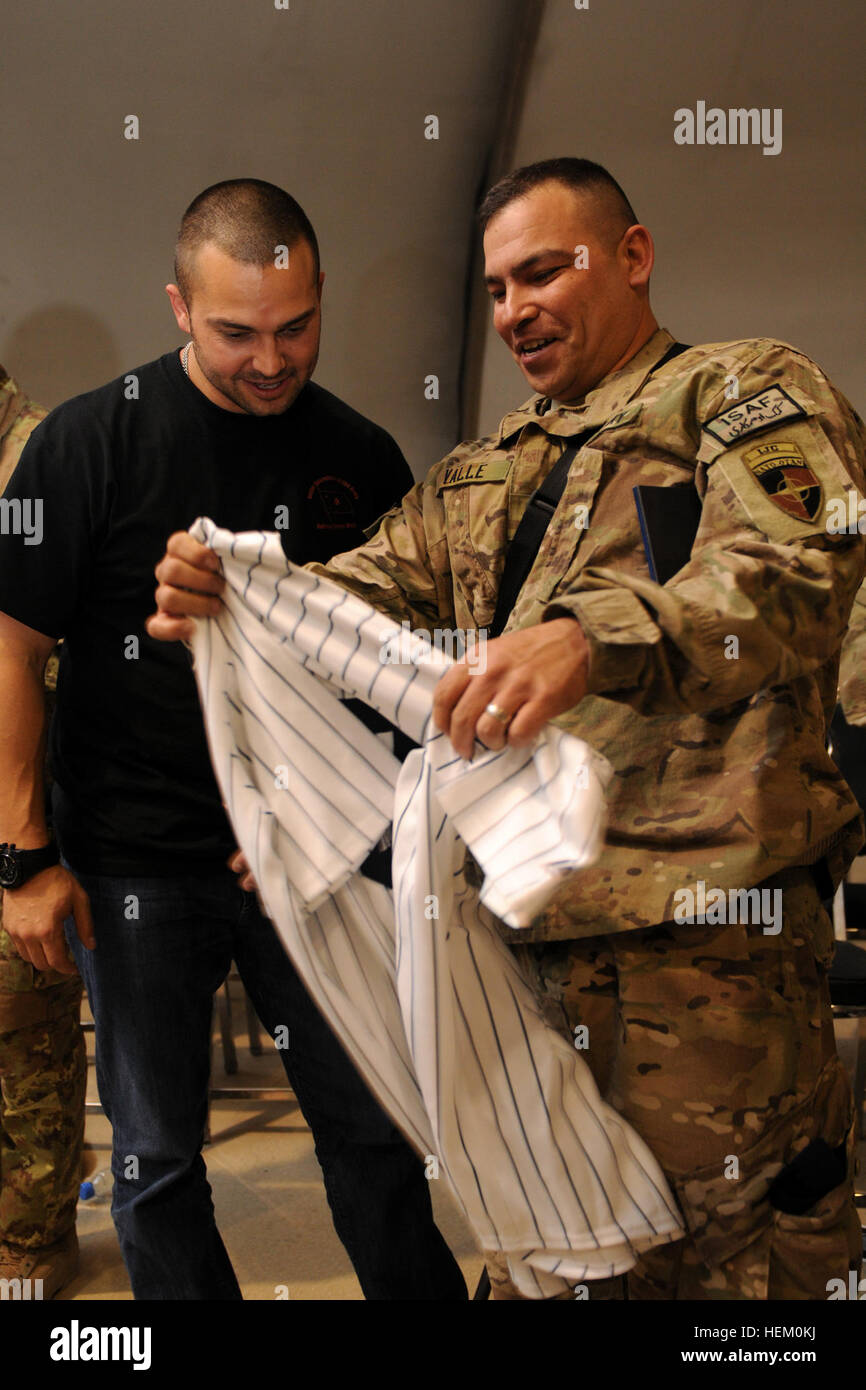 Spc. Raymond Valle, International Security Assistance Force Joint Command network administrator, prepares to have his New York Yankees jersey signed by Yankees outfielder Nick Swisher, Nov. 23, at Kabul International Airport. Swisher and his wife, JoAnna Garcia Swisher, will tour various bases around Afghanistan as part of the USO Thanksgiving Holiday Troop Visit. Swisher, wife kick off Afghanistan honeymoon 111123-A-CU451-002 Stock Photo