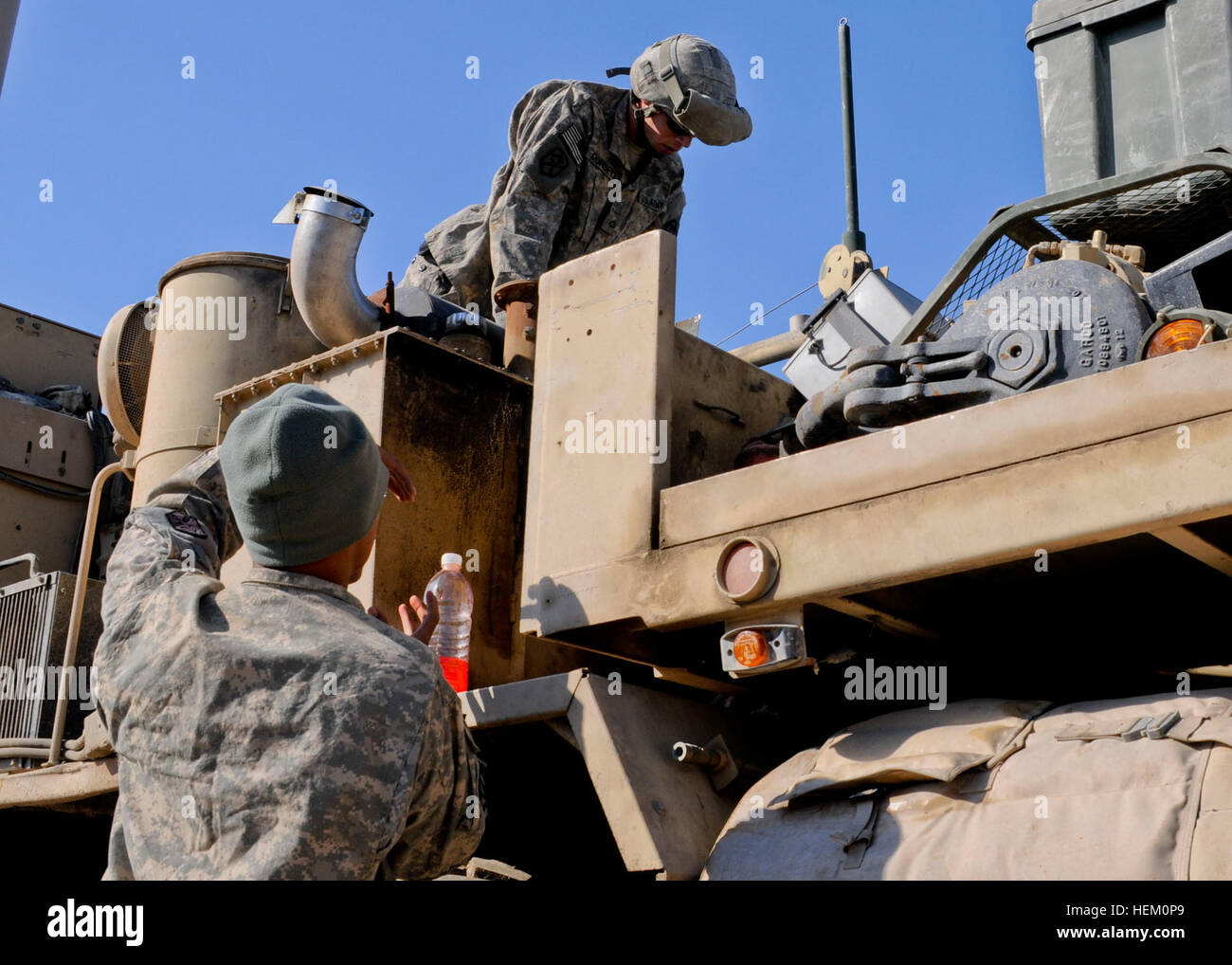 Soldiers with the 68th Transportation Company perform maintenance checks on an armored military wrecker on Contingency Operating Base Adder, Nov. 30. The unit prepared to make its final trip from Iraq to Kuwait after completing more than 30 missions since deploying in May. Mounting up for last ride out of Iraq 111130-A-JX739-069 Stock Photo
