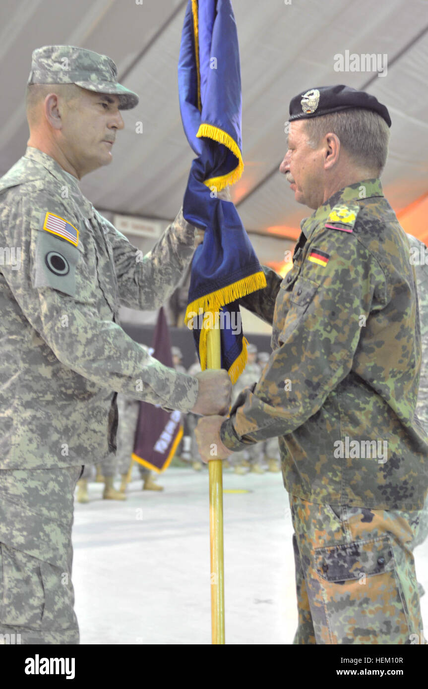 Army Col. Jeffrey J. Liethen, Wisconsin Army National Guard's 157th Maneuver Enhancement Brigade commander, left, receives the NATO flag from German Army Maj. Gen. Erhard Drews, Kosovo Forces commander, in a transfer of authority ceremony at Camp Bondsteel, Dec. 10, 2011. Wisconsin brigade takes command of Multinational Battle Group East mission 111210-A-VX723-151 Stock Photo