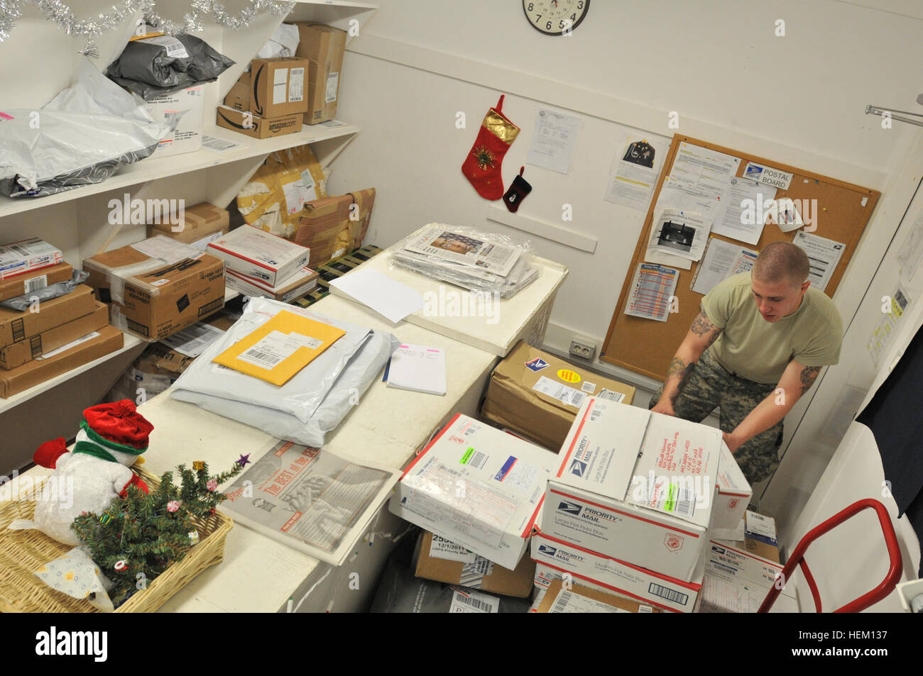 Pfc. Clinton Glenn, a driver and administrative assistant from the Georgia Army National Guard assigned to Multinational Battle Group - East, sorts through stacks of mail. Spreading holiday cheer is busy work 111212-A-VX723-002 Stock Photo