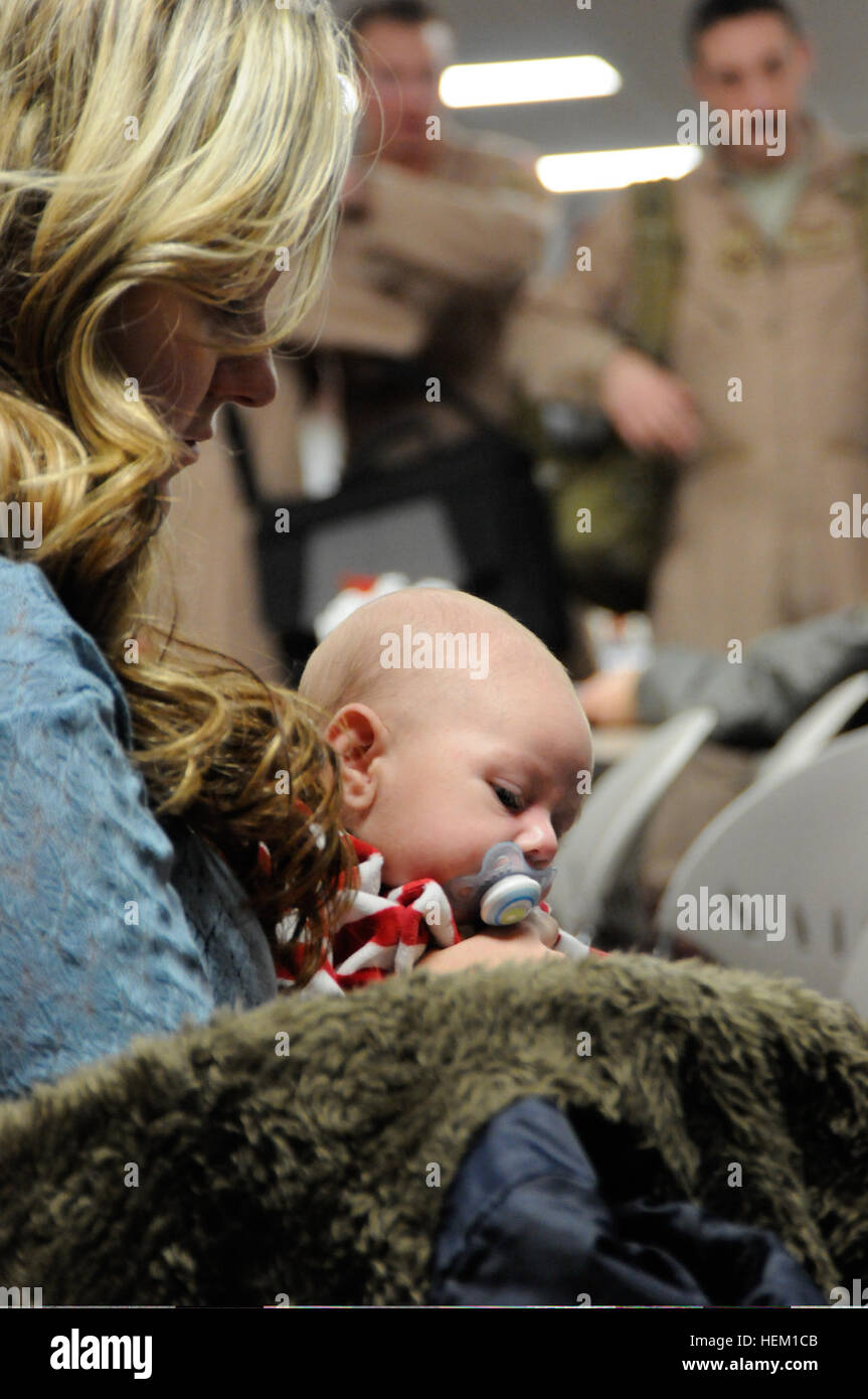 Alisha Klein, of Ogden, Utah, holds her son, Braxton Klein, while they wait for Staff Sgt. Robert Klein, of Phoenix, assigned to the 39th Airlift Squadron, 153rd Airlift Wing, Wyoming Air National Guard, Dec. 28, 2011, who returned that day from a deployment. Seventeen members of the 30th returned to the Wyoming Air National Guard Base, Cheyenne, Wyo. The unit's deployment was shortened from three months to just over 30 days due to a draw down in forces for Operations Iraqi Freedom and Operation Enduring Freedom. The Airmen were due back on Christmas, but a mechanical problem with the plane fo Stock Photo