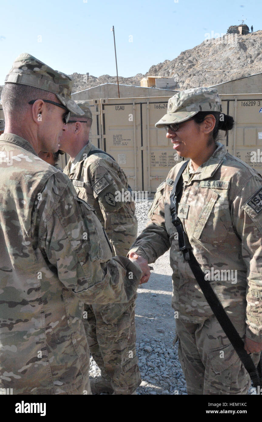 Sgt. Nazly Confesor receives a commander’s coin from Col. Todd Wood, commander of Task Force Arctic Wolves, at Forward Operating Base Masum Ghar in the Panjwa’i district of Southern Kandahar province. Female journalist meets the challenges in Panjwa%%%%%%%%E2%%%%%%%%80%%%%%%%%99i 120111-A-BE343-001 Stock Photo