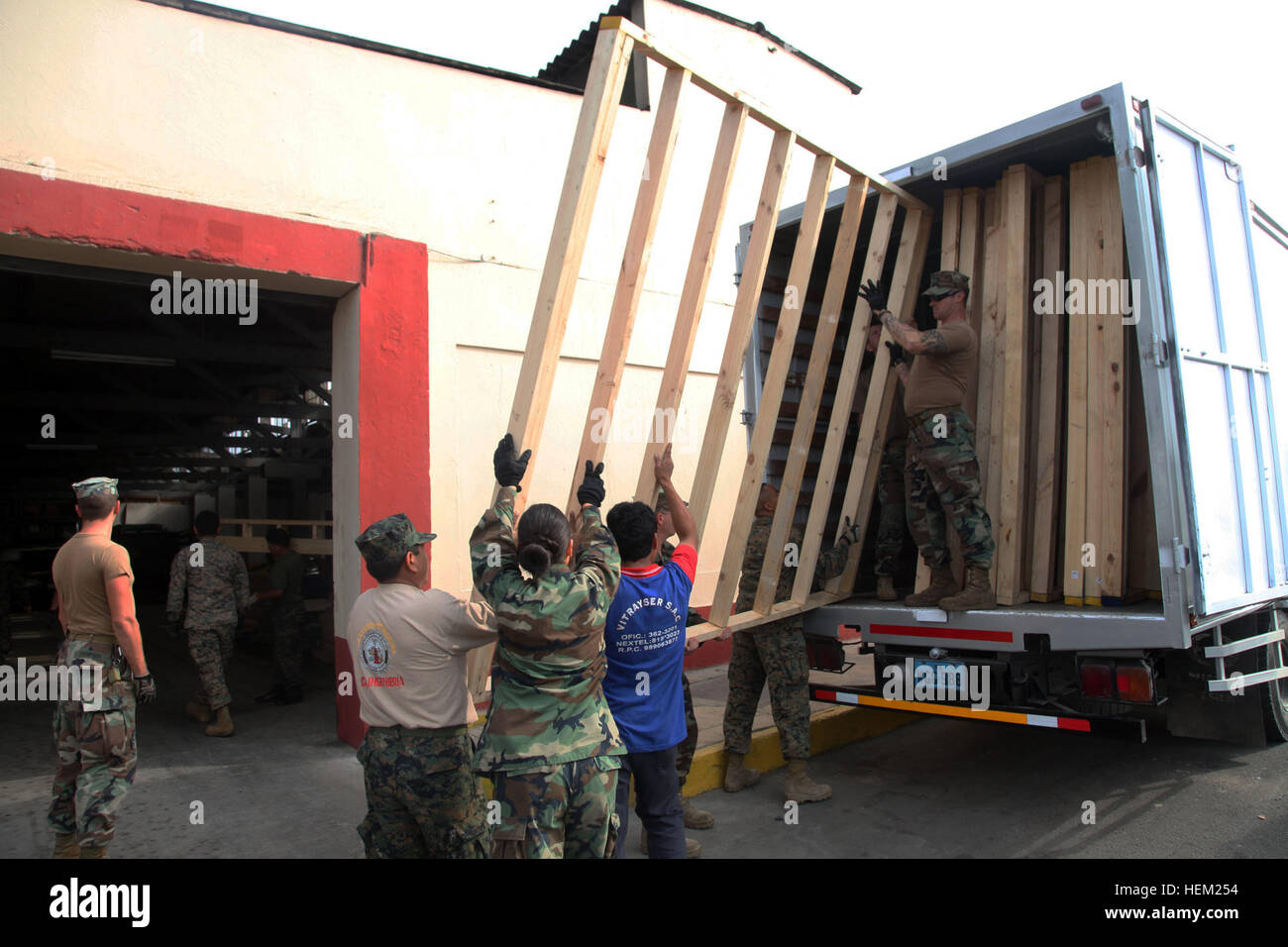 U.S. Navy Seabees, assigned to Navy Mobile Construction Battalion 23, embarked aboard High Speed Vessel Swift, carry prefabricated floors with service members from the Peruvian Marines Corp of Engineers and load them onto a truck. The two navies are working together at Callao Naval Base to build floors and walls that will be used at a school in Zona De Acapulco and Ancon, as part of Southern Partnership Station 2012. The Seabees and engineers will spend three weeks refurbishing two schools in the area. HSV-SPS 12 is an annual deployment of U.S. Navy ships and assets to the U.S. Southern Comman Stock Photo