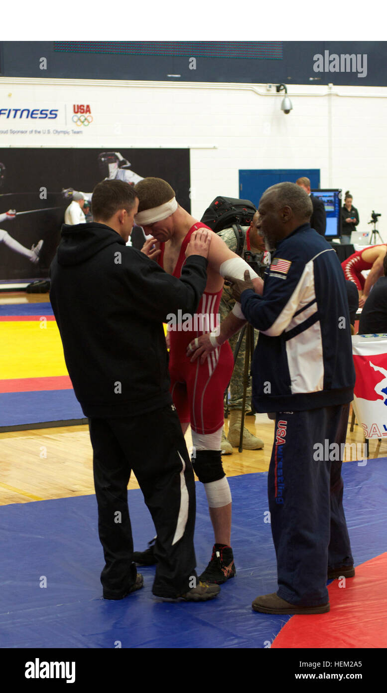 Captain Derek Moore, field artillery officer, 4th Battalion, 42nd Field Artillery Regiment, 1st Brigade Combat Team, 4th Infantry Division, confers with his coaches during a pause in the Dave Schultz Memorial International Tournament, at the Colorado Springs Olympic Training Center, Colo., Feb. 3, 2012. Moore, who has wrestled for 16 years, joined the wrestling program at Fort Carson, Colo., in 2008. After becoming a member of the Army World Class Athlete Program, his unit allowed him to focus his efforts on wrestling to prepare for the Olympics. Coaching 120203-A-no003-055 Stock Photo