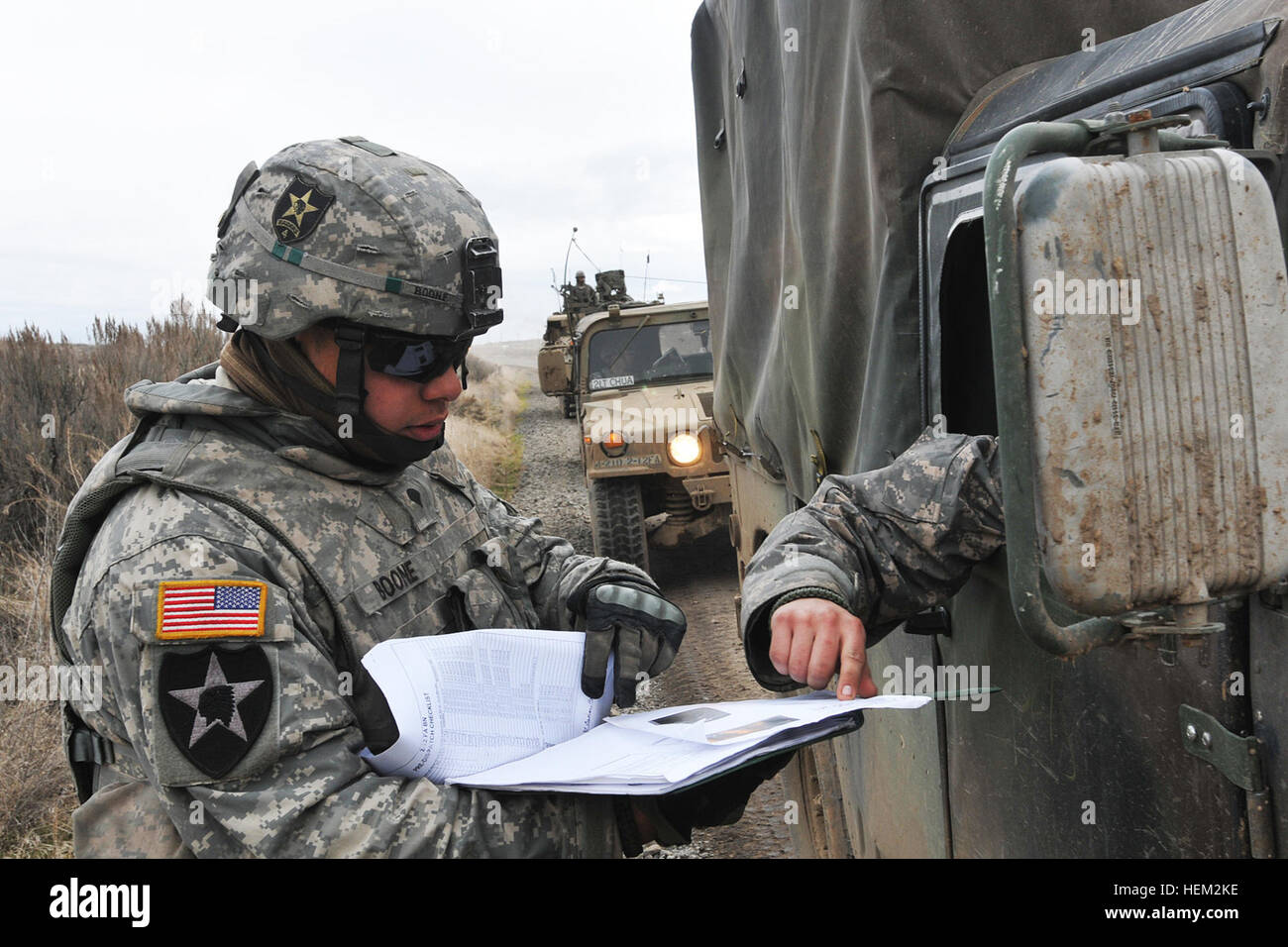 Soldiers with the Military Police Platoon, Headquarters and Headquarters  Company, 4th Stryker Brigade Combat Team, 2nd Infantry Division, verify the  driver's licenses and vehicle dispatch of soldiers in a convoy at a