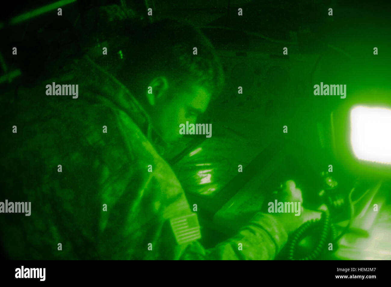Sgt. Cody Schroeder of La Pine, Ore., an air traffic controller assigned to Task Force Saber, tracks a helicopter on a map, lit only by the display on his radio on Forward Operating Base Miami during TF Saber's February rotation to the National Training Center at Fort Irwin, Calif. Army air traffic controller 536211 Stock Photo
