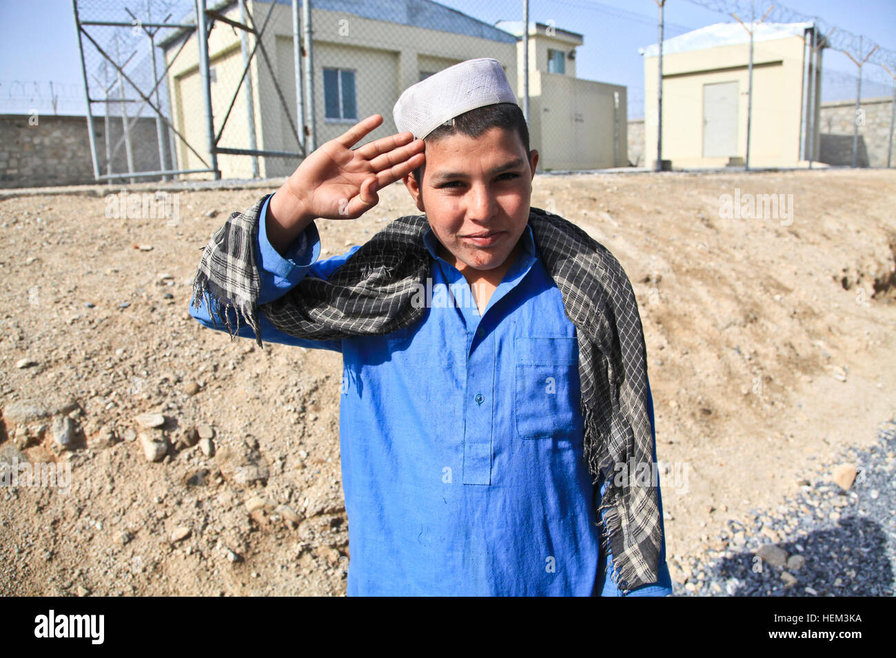 A local Afghan boy salutes U.S. soldiers within an Afghan Border Police compound, Nazyan district, Nangarhar province, Afghanistan, March 15, 2012. The purpose of the mission was to gain familiarization of the district and key leadership. Key leader engagement 120315-A-LP603-002 Stock Photo