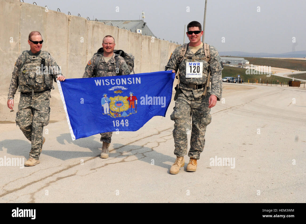 Wisconsin Army National Guard Soldiers (left to right) Lt. Col. Kerry Morgan, chief of staff; Lt. Col. Jon Russell, operations officer; and Maj. Matthew Beilfuss, deputy operations officer, cross the finish line of the 13.1-mile Bataan Memorial Death March at Camp Bondsteel, Kosovo March 26. The Soldiers are assigned to Multinational Battle Group East. Task Force Falcon photo Bataan Memorial Death March at Camp Bondsteel 791103 Stock Photo