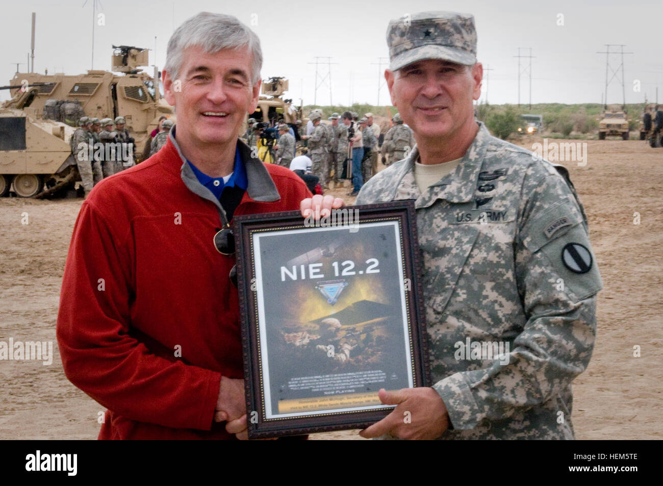 Brig. Gen. Randal Dragon, commander of Brigade Modernization Command, presents Secretary John McHugh, the 21st secretary of the Army, with a plaque to thank him for his visit to Network Integration Evaluation 12.2 on Fort Bliss, Texas, May 9. Secretary McHugh toured the NIE, a soldier-led evaluation process that tests network and non-network equipment in a robust operational environment. 'I think it's a great day to be in the Army - for [Sec. McHugh] to be here to witness what the soldiers of 2nd Brigade, 1st Armored Division, are doing for our Army, and to take a look at the type of systems w Stock Photo