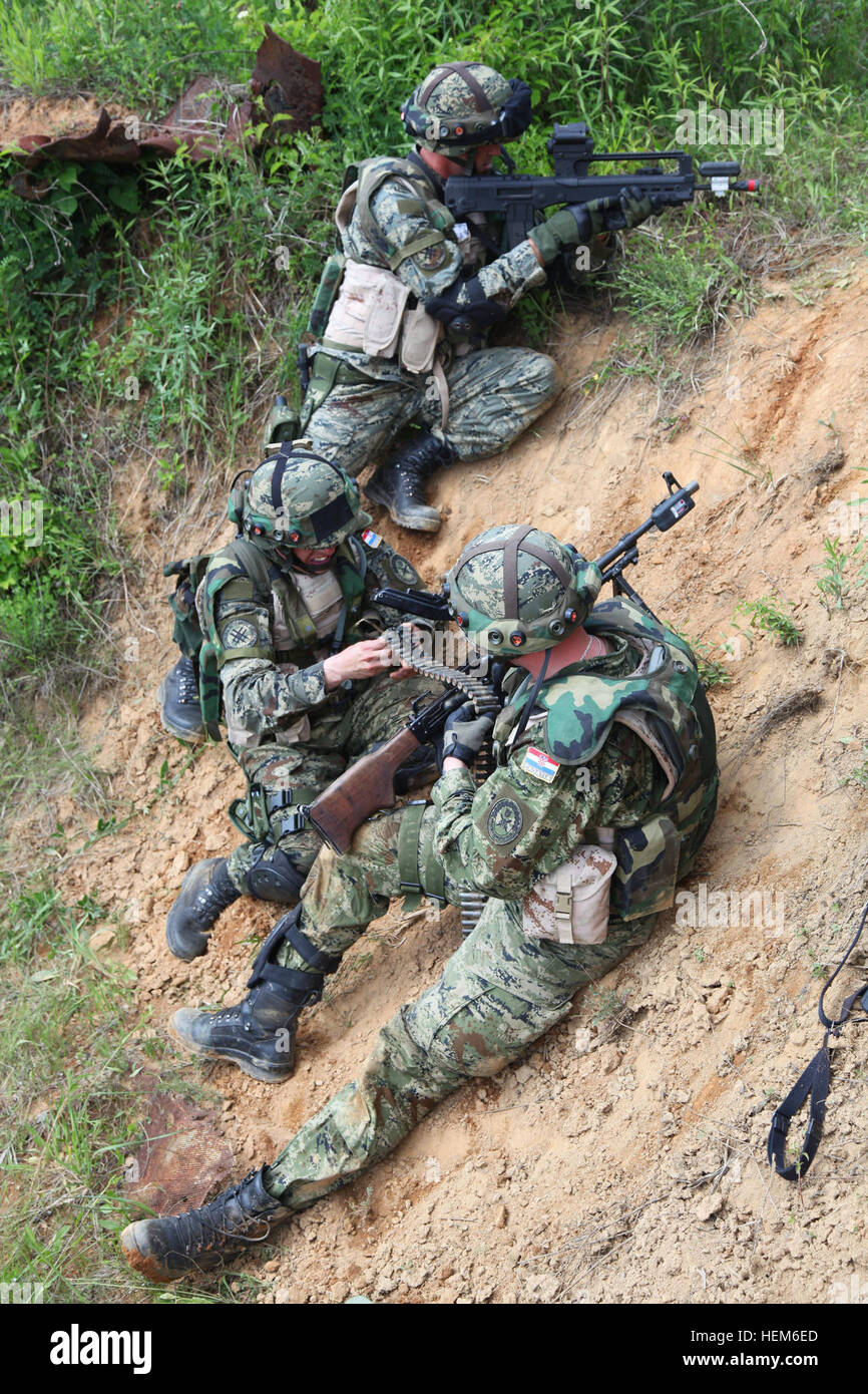 Soldiers from 1st Platoon, 1st Company, Tiger Battalion, from the Croatian Army take cover and return fire after encountering enemy contact as they conduct a movement to contact exercise during the Immediate Response 2012 (IR12) training event held in Slunj, Croatia on Tuesday, May 29, 2012.  IR12 is a multinational tactical field training exercise that will involve more than 700 personnel primarily from the U.S. Army Europe’s 2nd Calvary Regiment and Croatian armed forces, with contingents from Albania, Bosnia-Herzegovina, Montenegro and Slovenia. Macedonia and Serbia will send observers to t Stock Photo